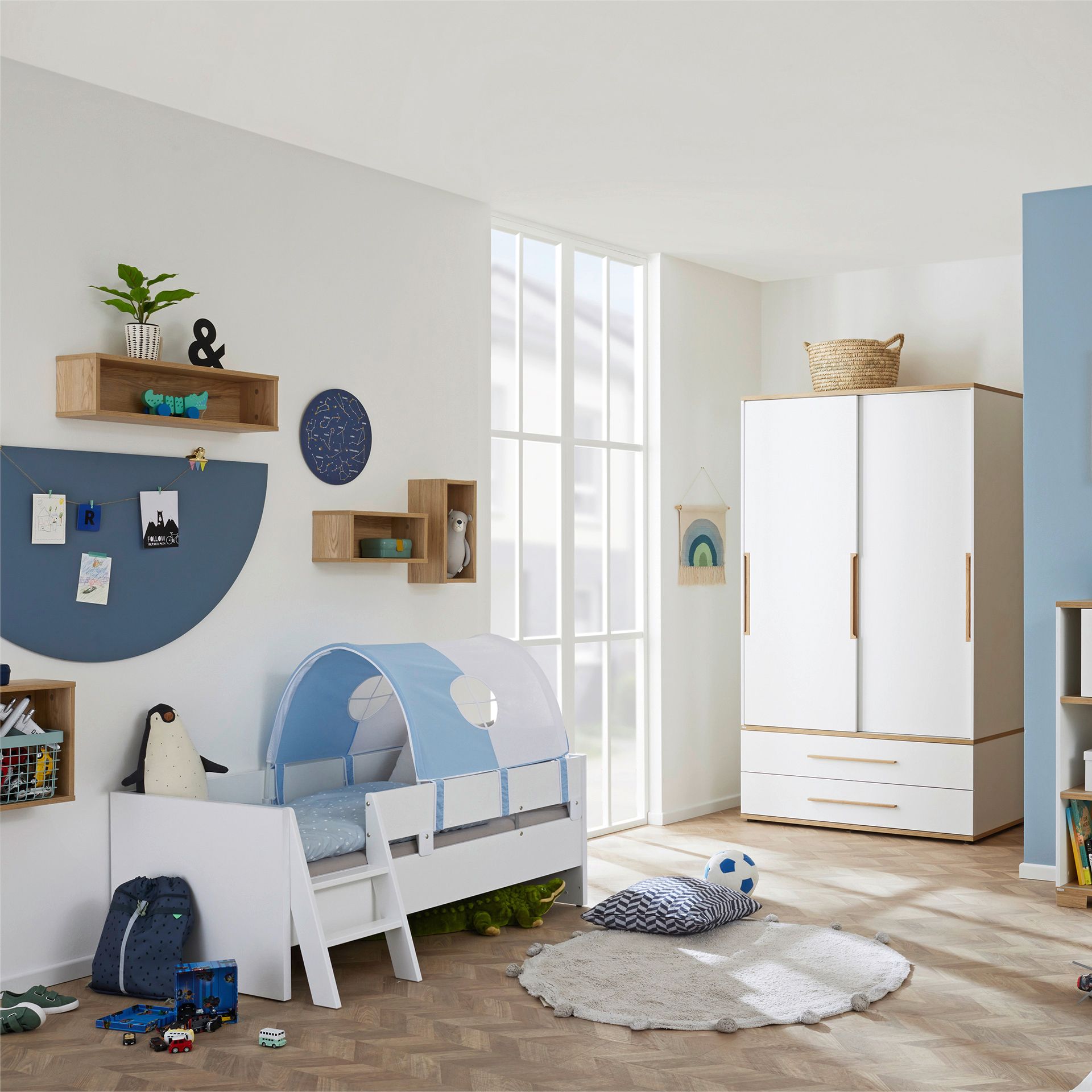 Modern childrens bedroom with a bed tent, toys, shelves, and a wardrobe.