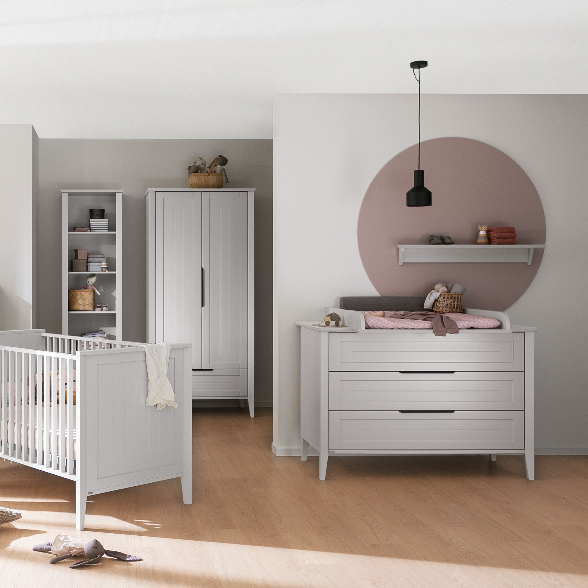 Modern nursery with white furniture, crib, dresser, and neutral decor.