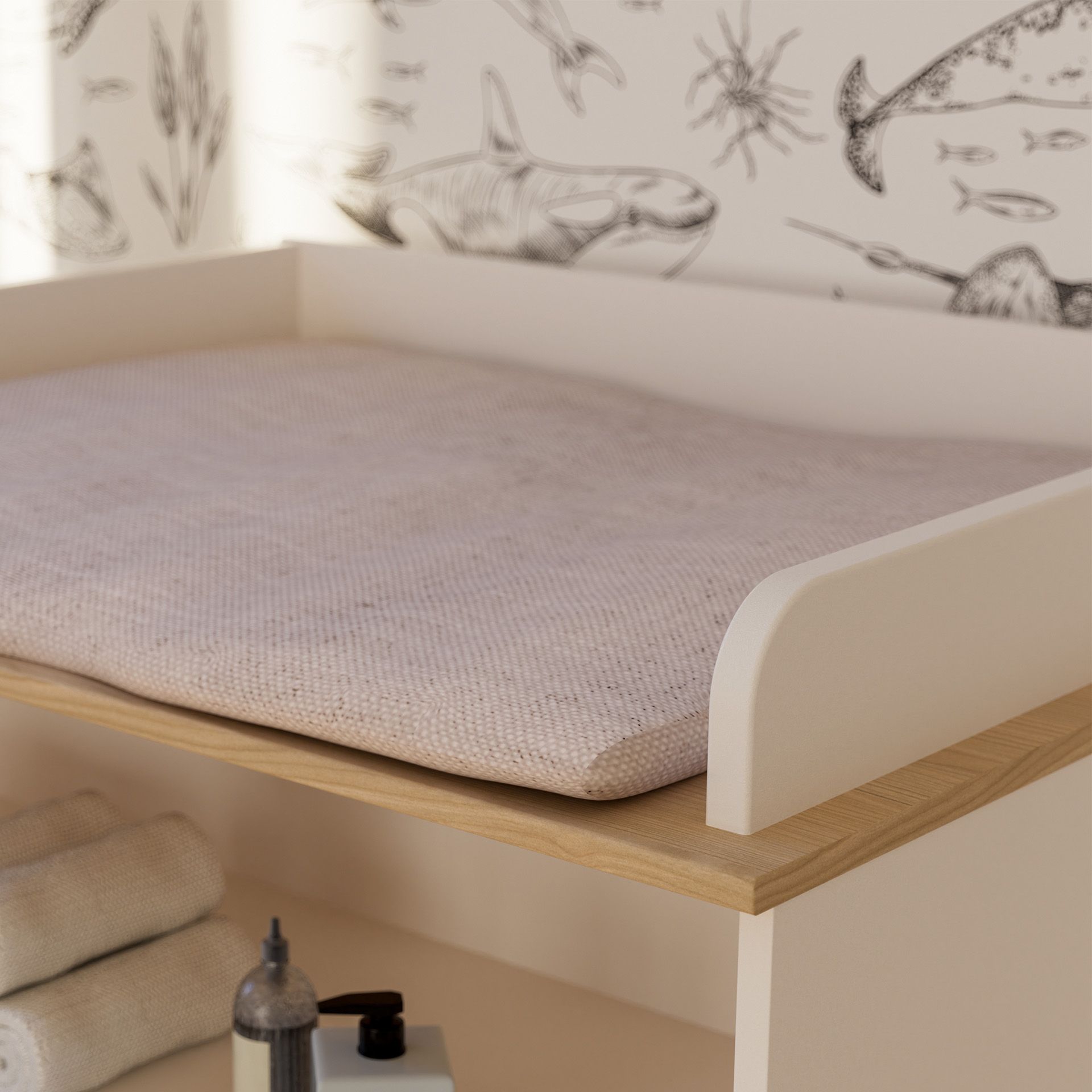 Wickelkommode Suzie mit 2 Türen und 1 offenen Fach Wickeltisch mit einer weichen Unterlage und einer Meerestiertapete im Hintergrund.