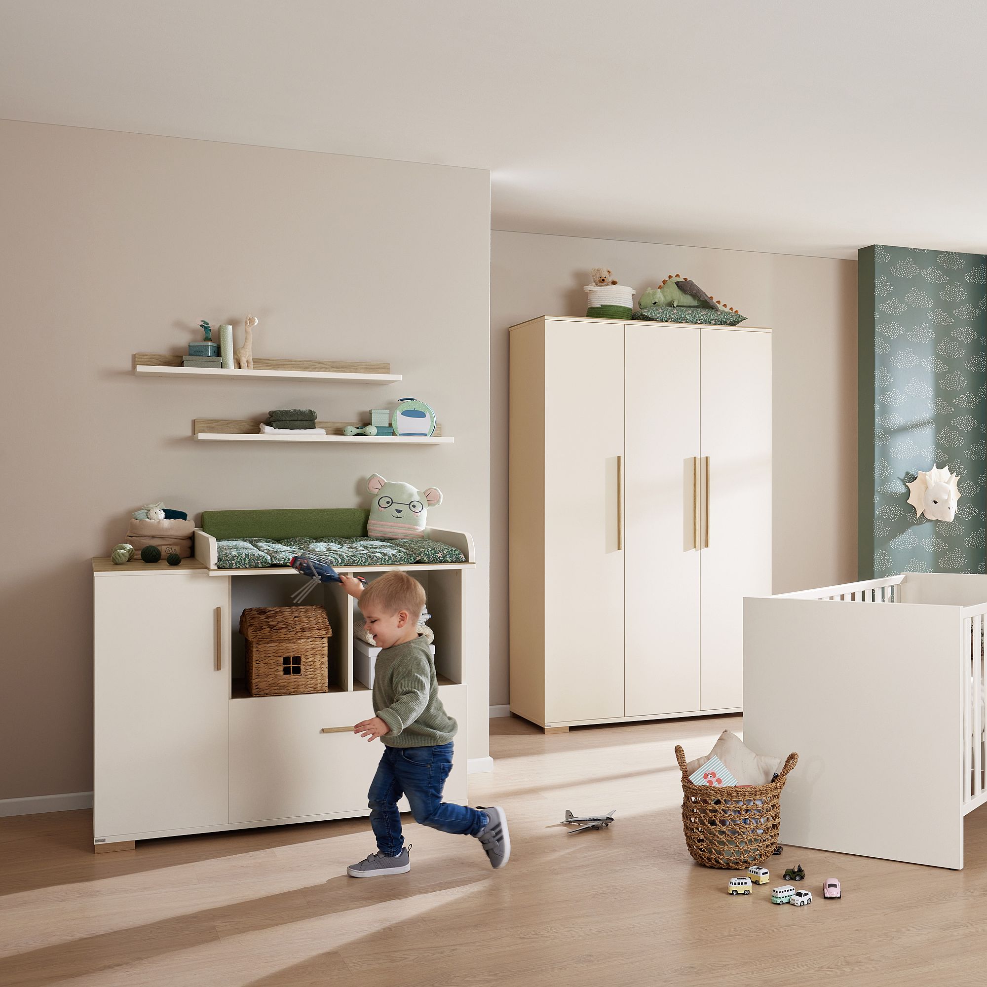 Ein Kleinkind rennt durch ein modernes Kinderzimmer mit Spielzeug, Schränken und einem Kinderbett.