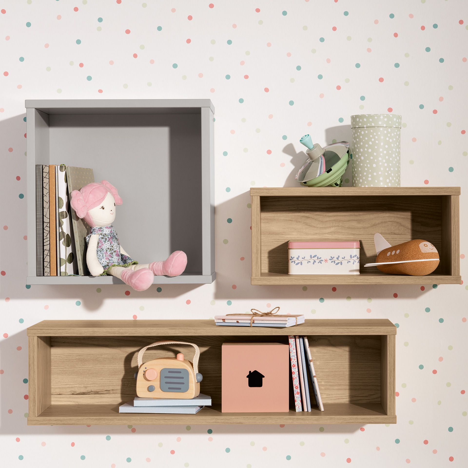 Wandregal  Wandbox  rechteckig  in Eiche-Montana Drei Wandregale mit Spielzeug, Büchern und Dekoration vor einer gepunkteten Wand.