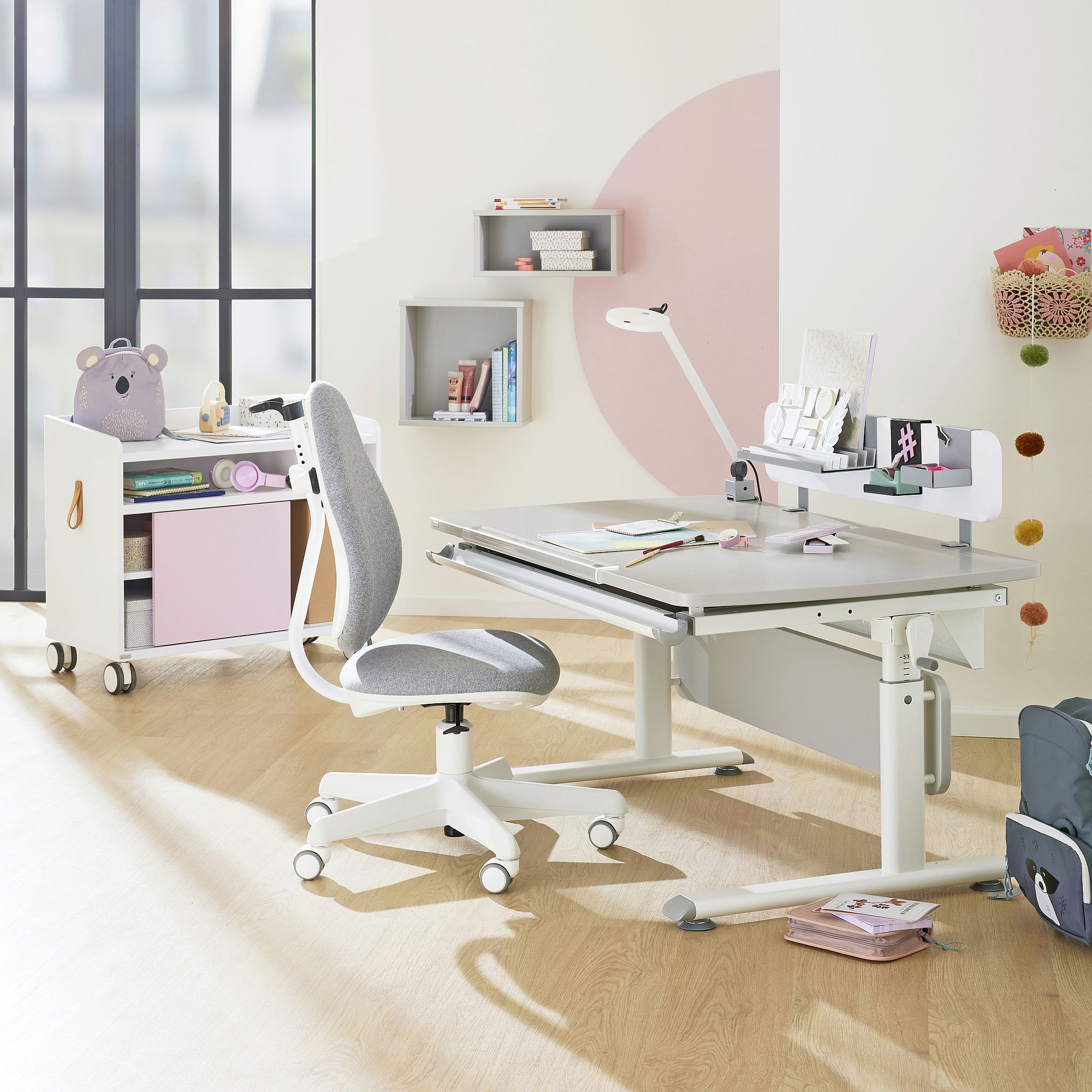 Rollcontainer Rollcaddy mit 1 Schiebetür in Rose Moderner Kinderschreibtisch und -stuhl in einem hellen, organisierten Raum.