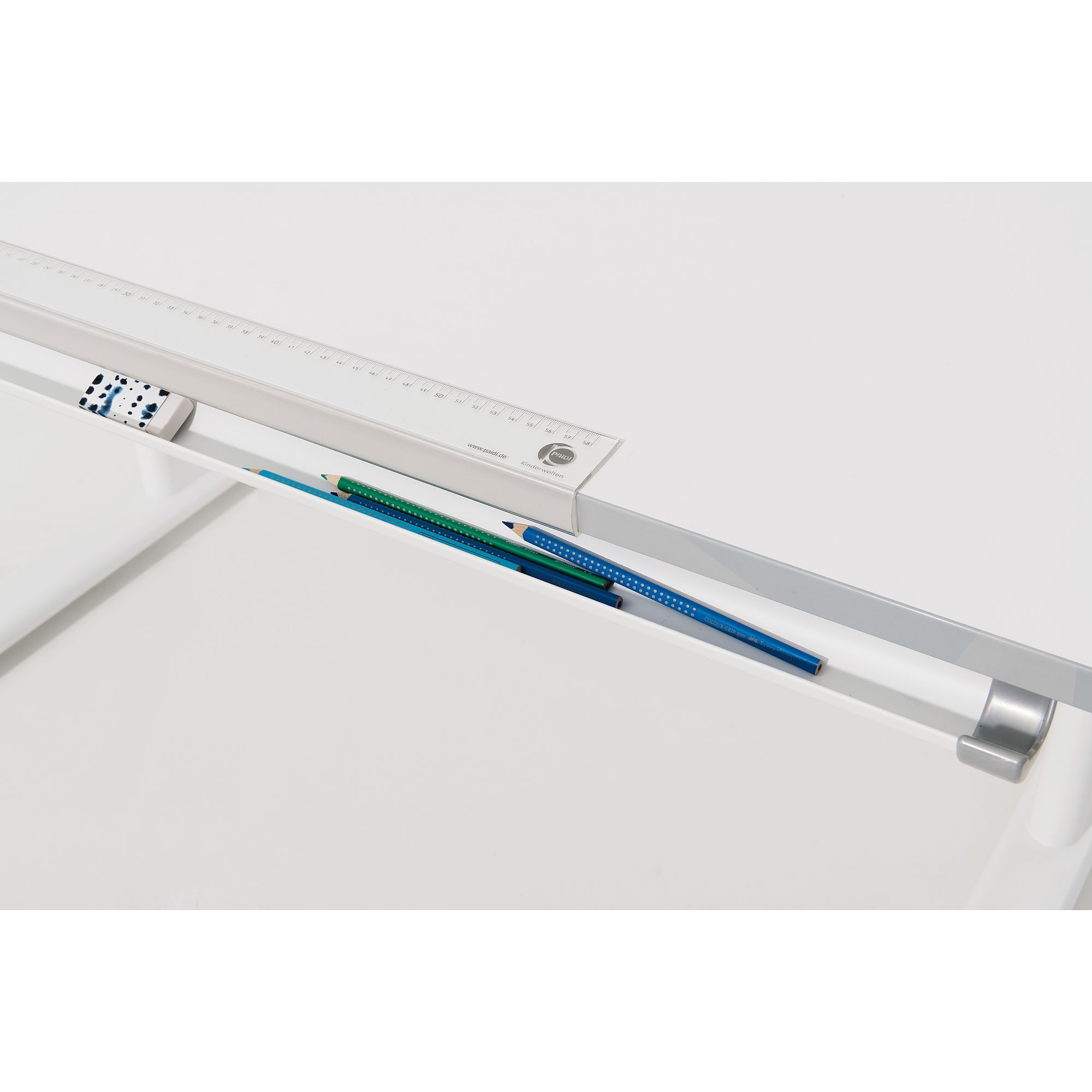 Weißer Schreibtisch mit Lineal, Bleistiften und Radiergummi in einer eingebauten Rille.