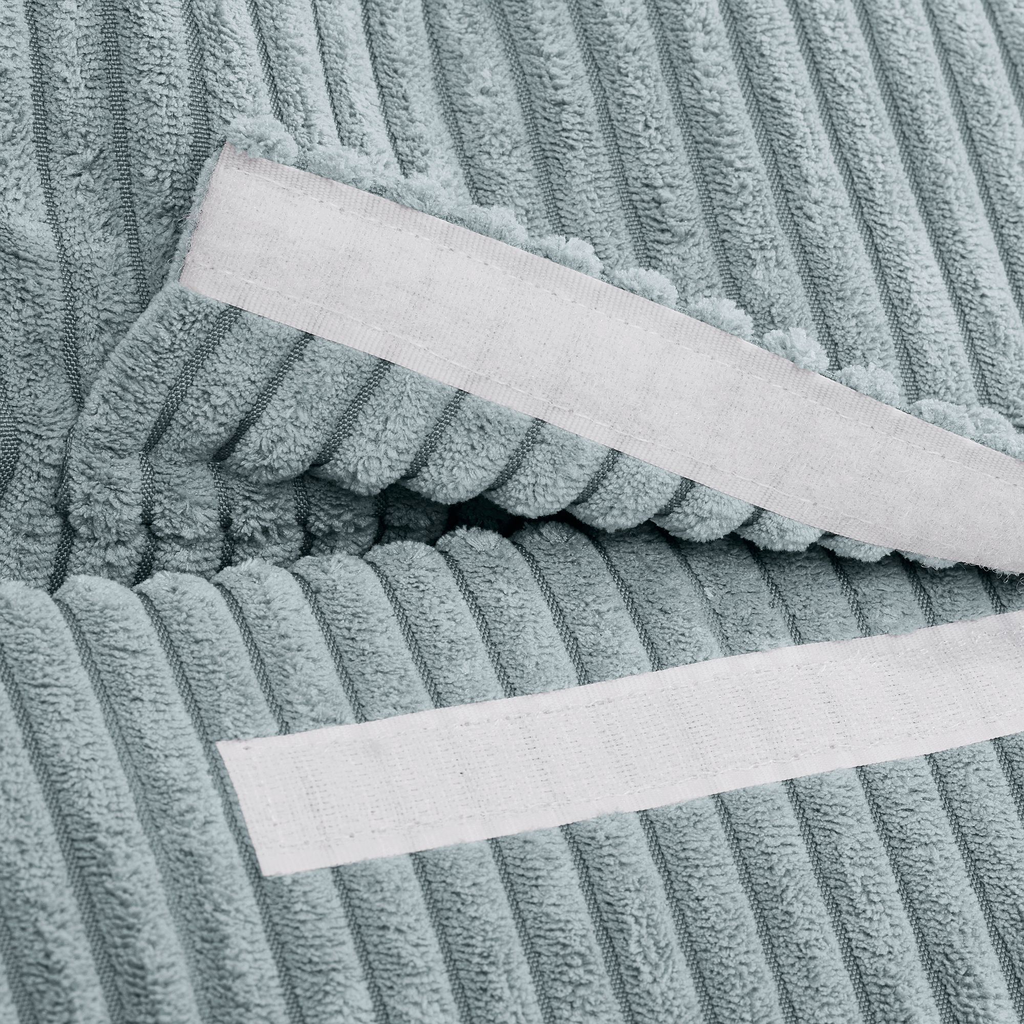 Nahaufnahme eines strukturierten, blauen, gerippten Stoffes, an dem zwei weiße Streifen befestigt sind.