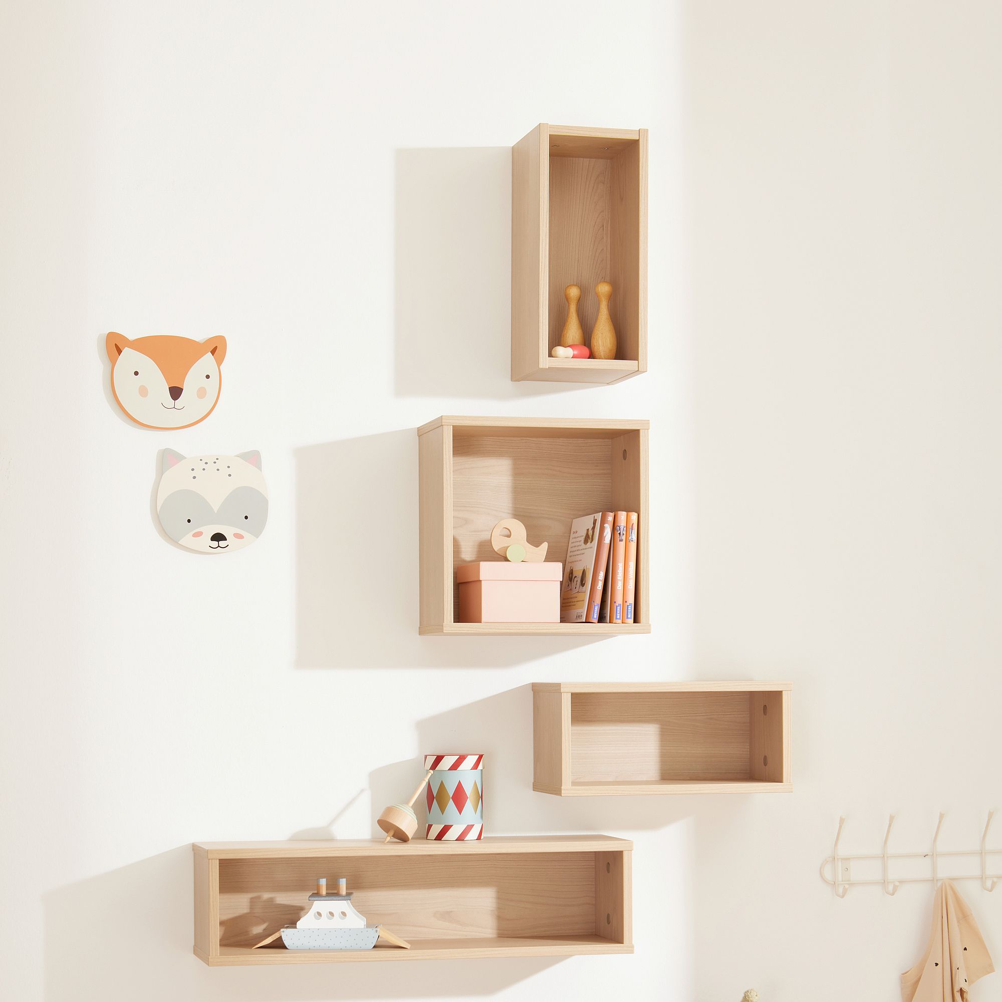 Wandregal  Wandbox  quadratisch in Scandinavian-Wood Hölzerne Wandregale mit Spielzeug, Büchern und Tiergesichtern an einer weißen Wand.