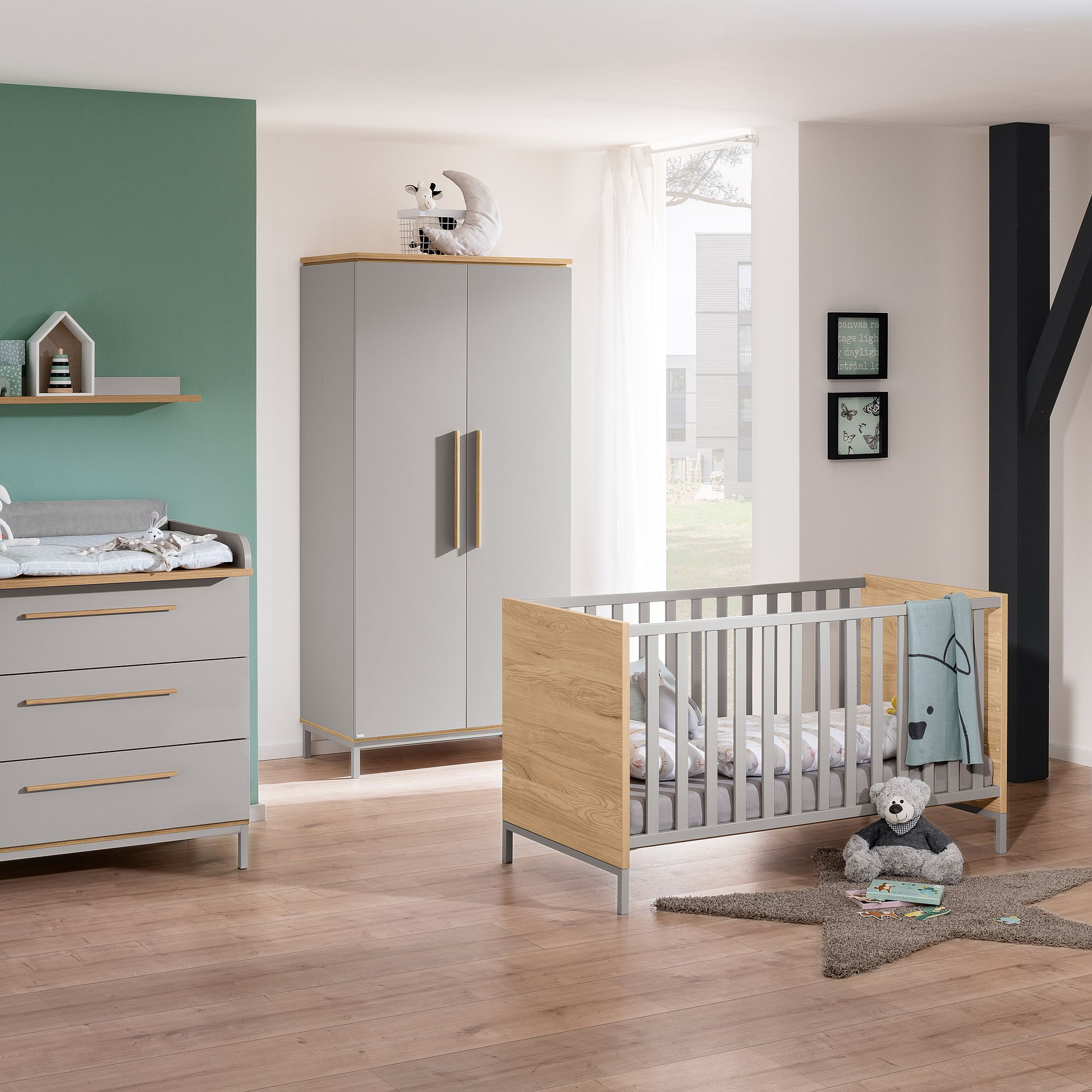 Modernes Kinderzimmer mit Kinderbett, Kleiderschrank, Wickeltisch und Spielzeug auf dem Boden.