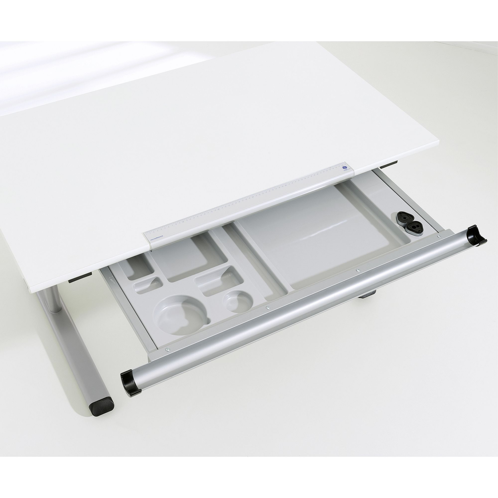 A white desk with an open gray organizer drawer beneath the tabletop.