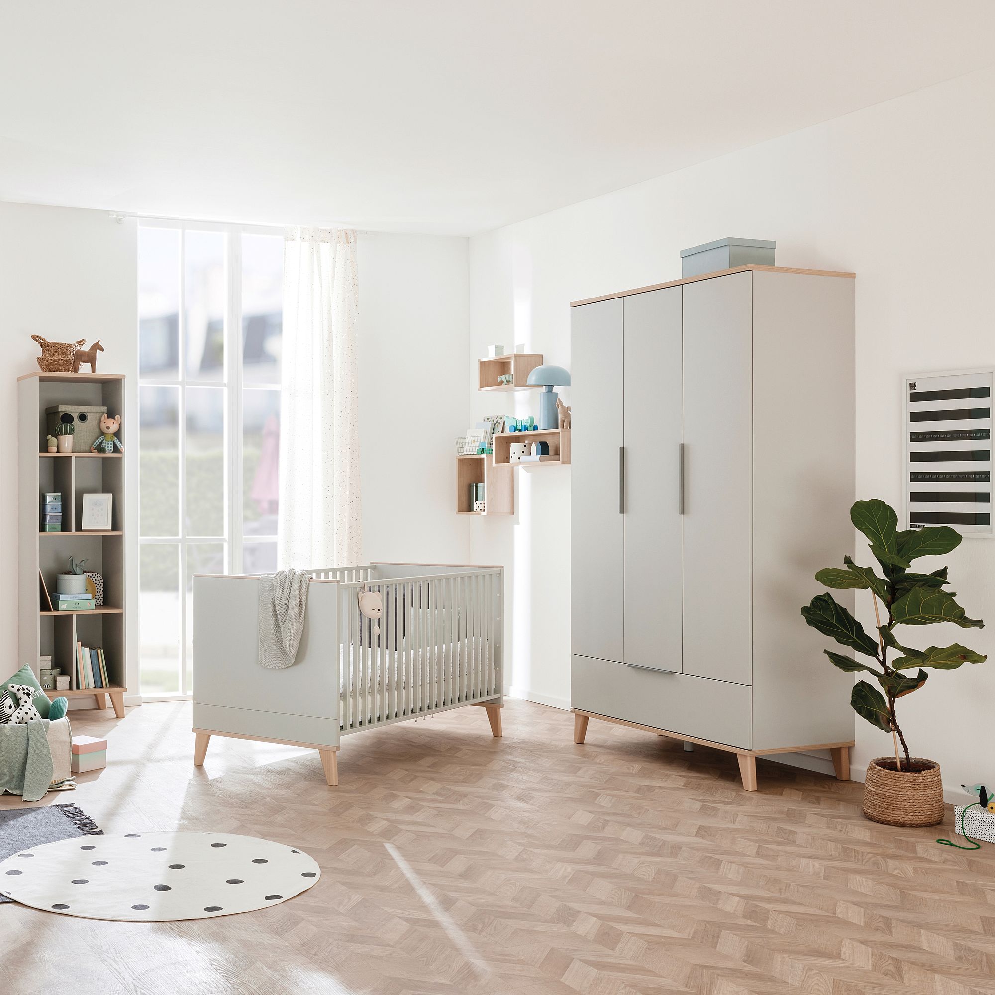 Drehtürenschrank Fiene 3 Türen, 1 Schublade Modernes Kinderzimmer mit einem Kinderbett, einem Kleiderschrank, einem Bücherregal und einer Topfpflanze.