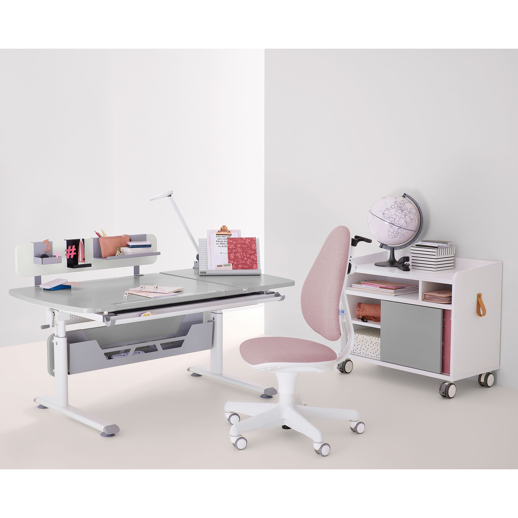 Schülerschreibtisch Diego GT Curved mit geteilter Platte 130 x 70 cm in Kieselgrau Moderner Schreibtisch mit rosa Stuhl, Globus, Büchern und Schreibtischzubehör.