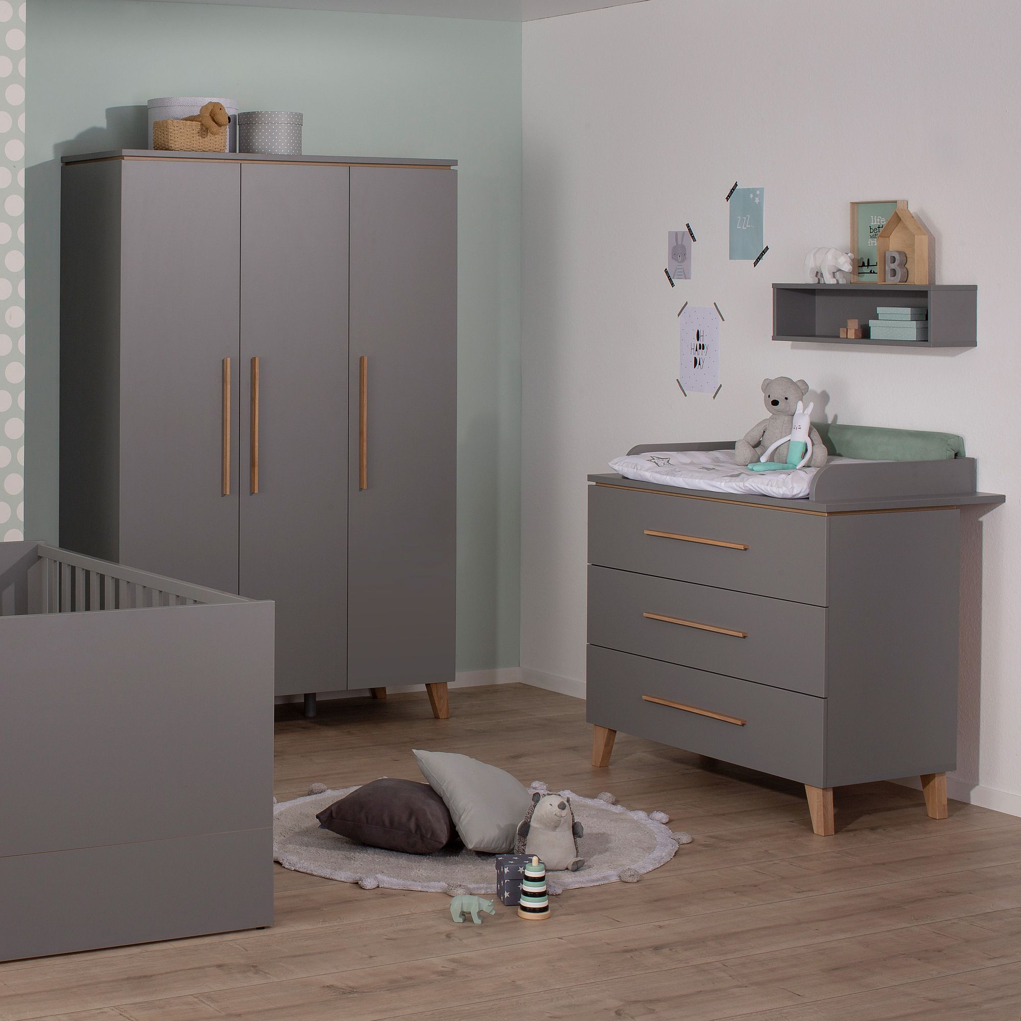 Modernes Babyzimmer mit grauen Möbeln, Holzakzenten, Spielzeug und Wanddekoration.