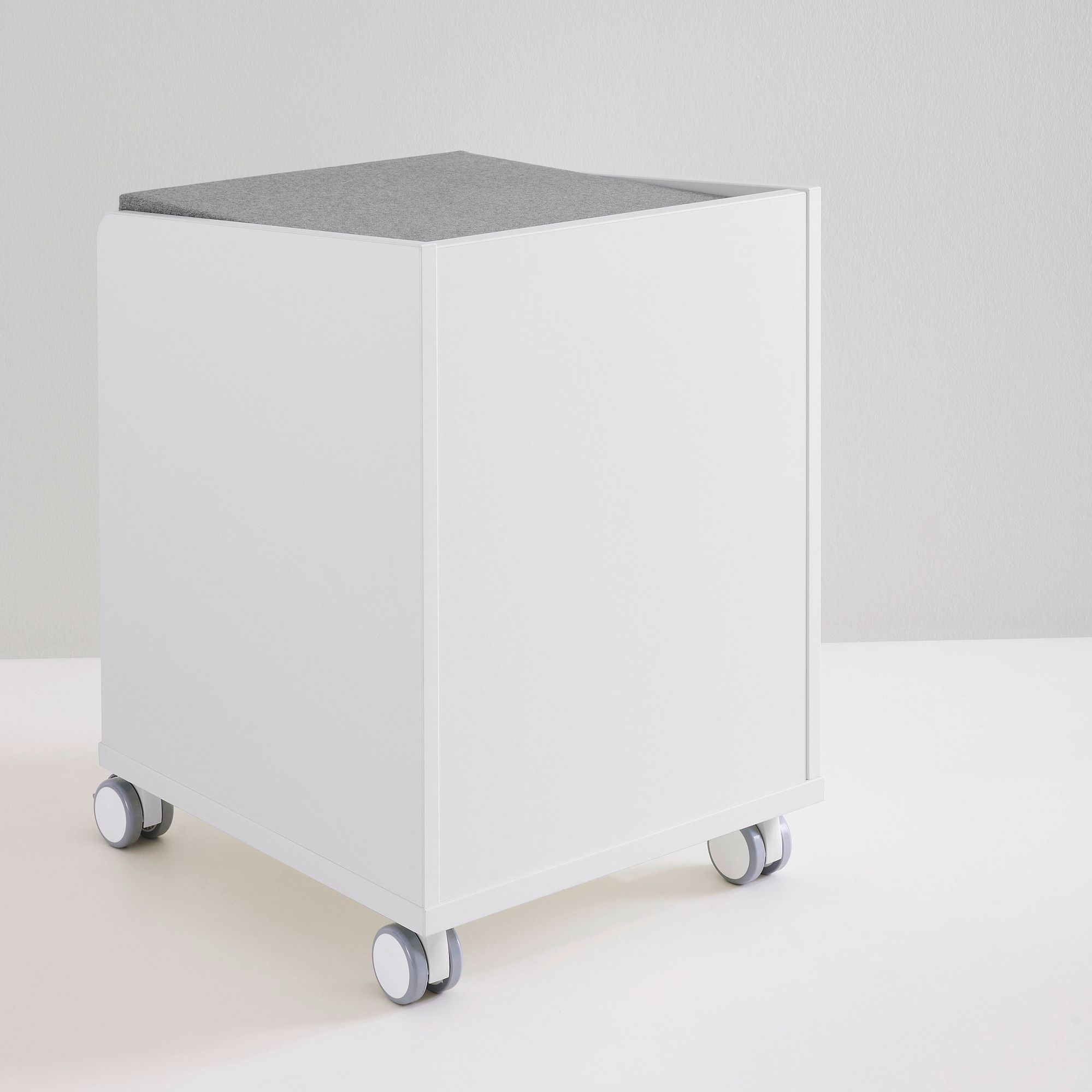 Rollcontainer  mit 2 Schubladen in Kreideweiß Weißer Aufbewahrungswürfel auf Rädern mit grauer, gepolsterter Oberseite vor einfarbigem Hintergrund.