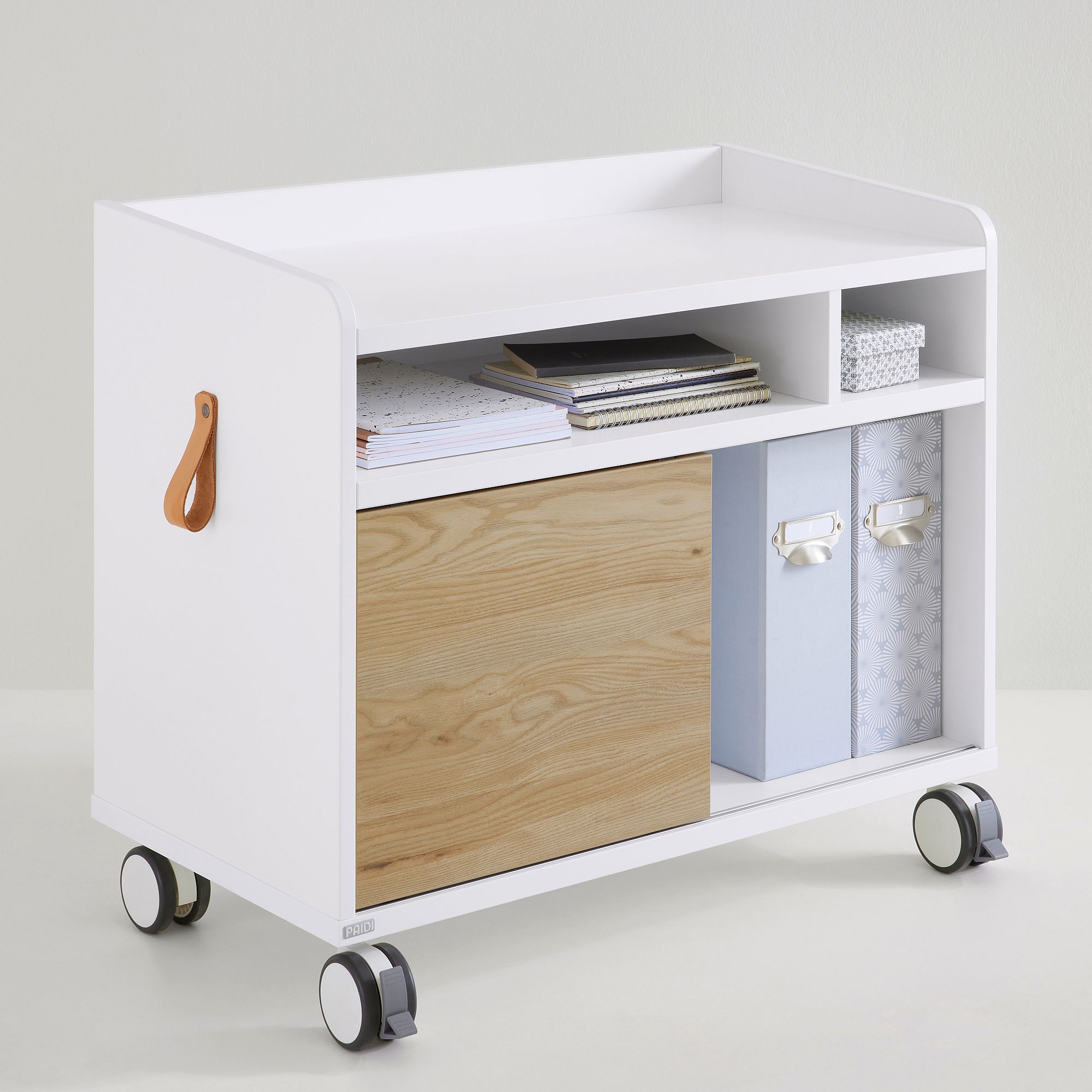 Rollcontainer Rollcaddy mit 1 Schiebetür in Eiche-Montana Weißer rollender Lagerwagen mit Regalen, Kisten und einer holzgetäfelten Tür.