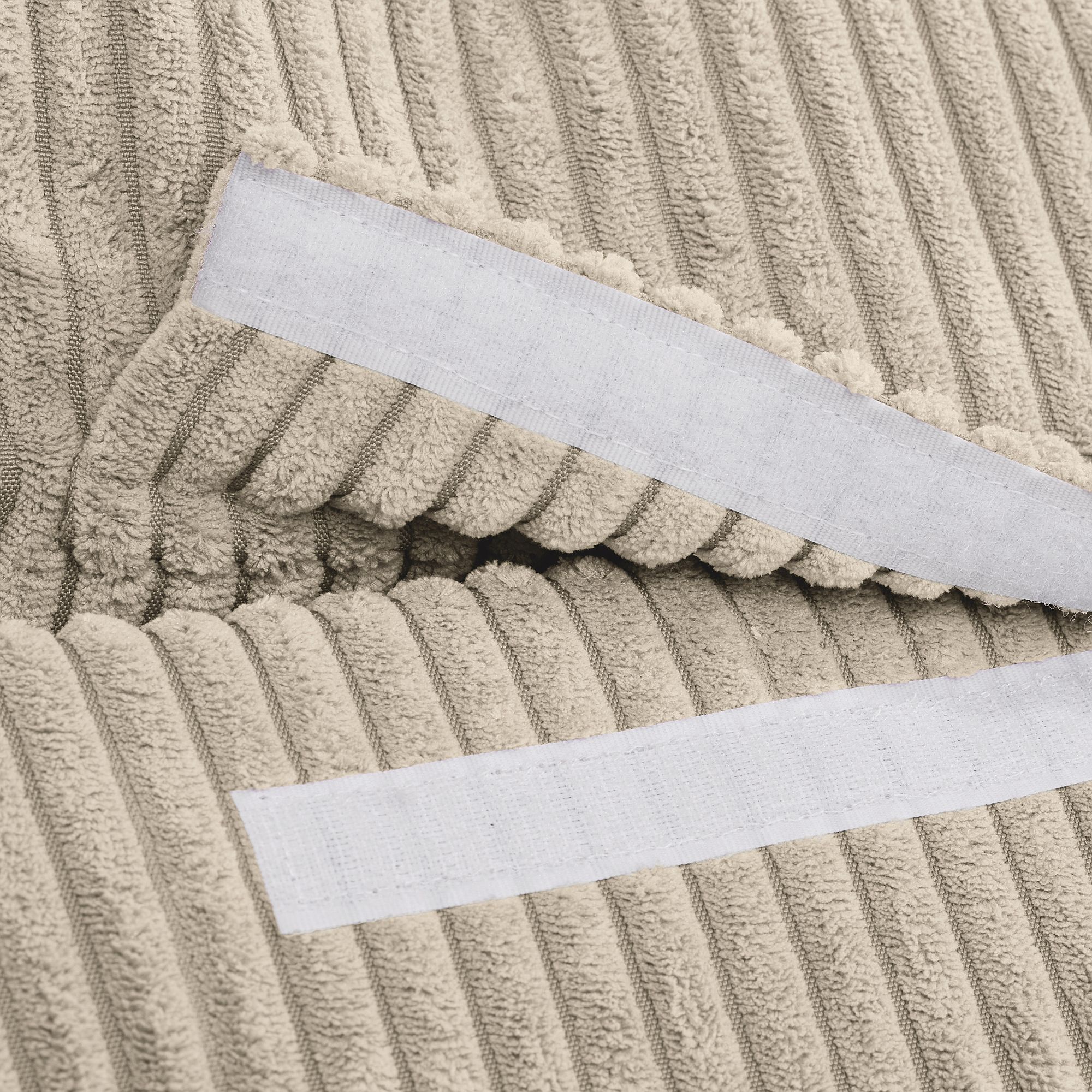 Beigefarbener Rippenstoff mit zwei weißen Klettverschlussstreifen.