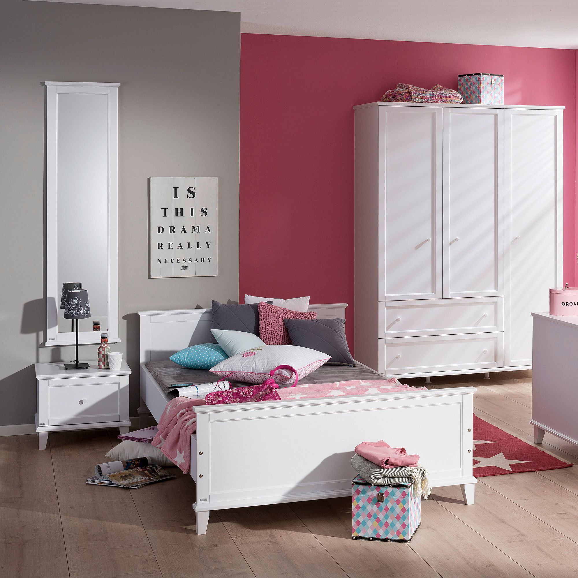 A tidy bedroom with white furniture, pink accents, and decorative pillows.