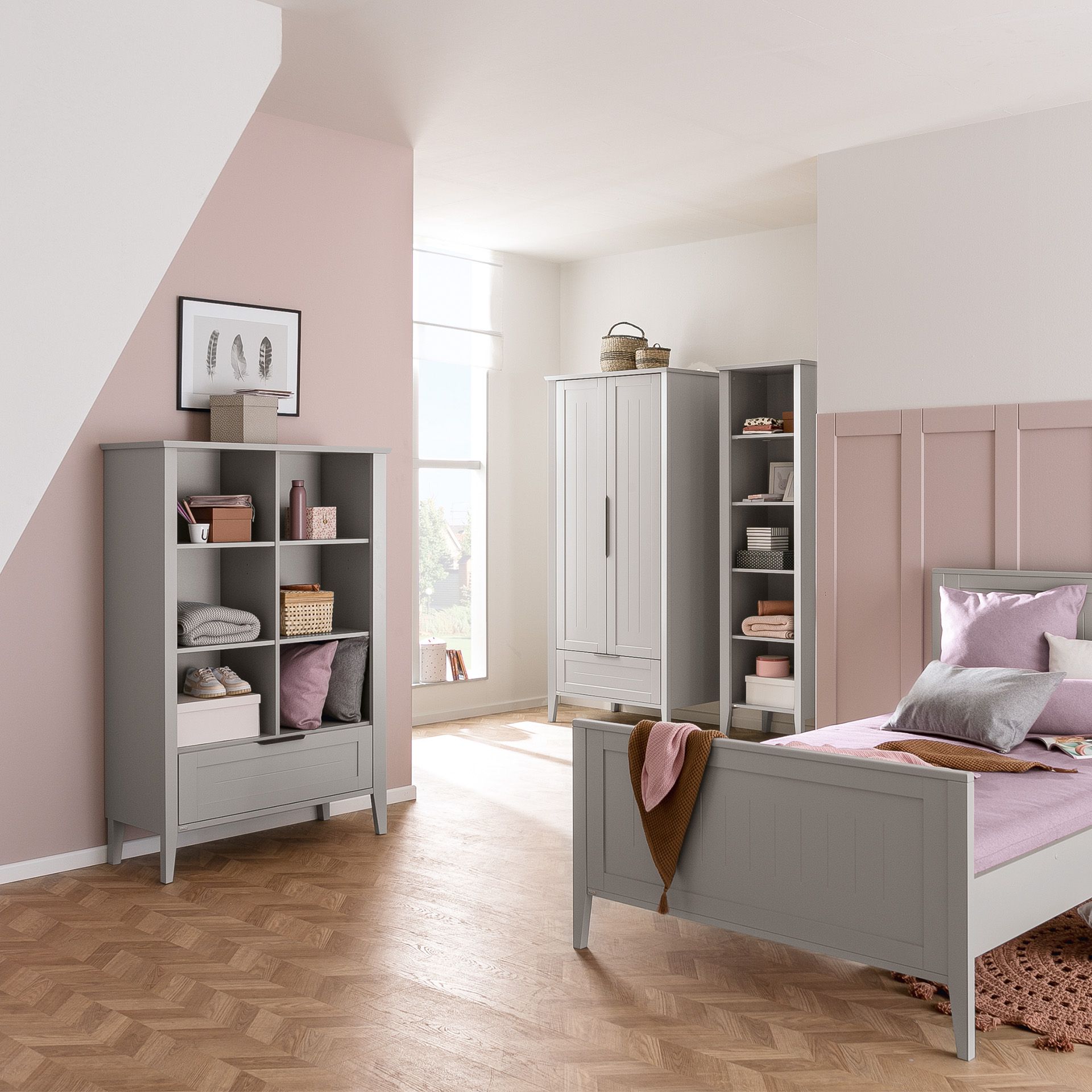 A pastel pink and gray bedroom with modern furniture and natural light.