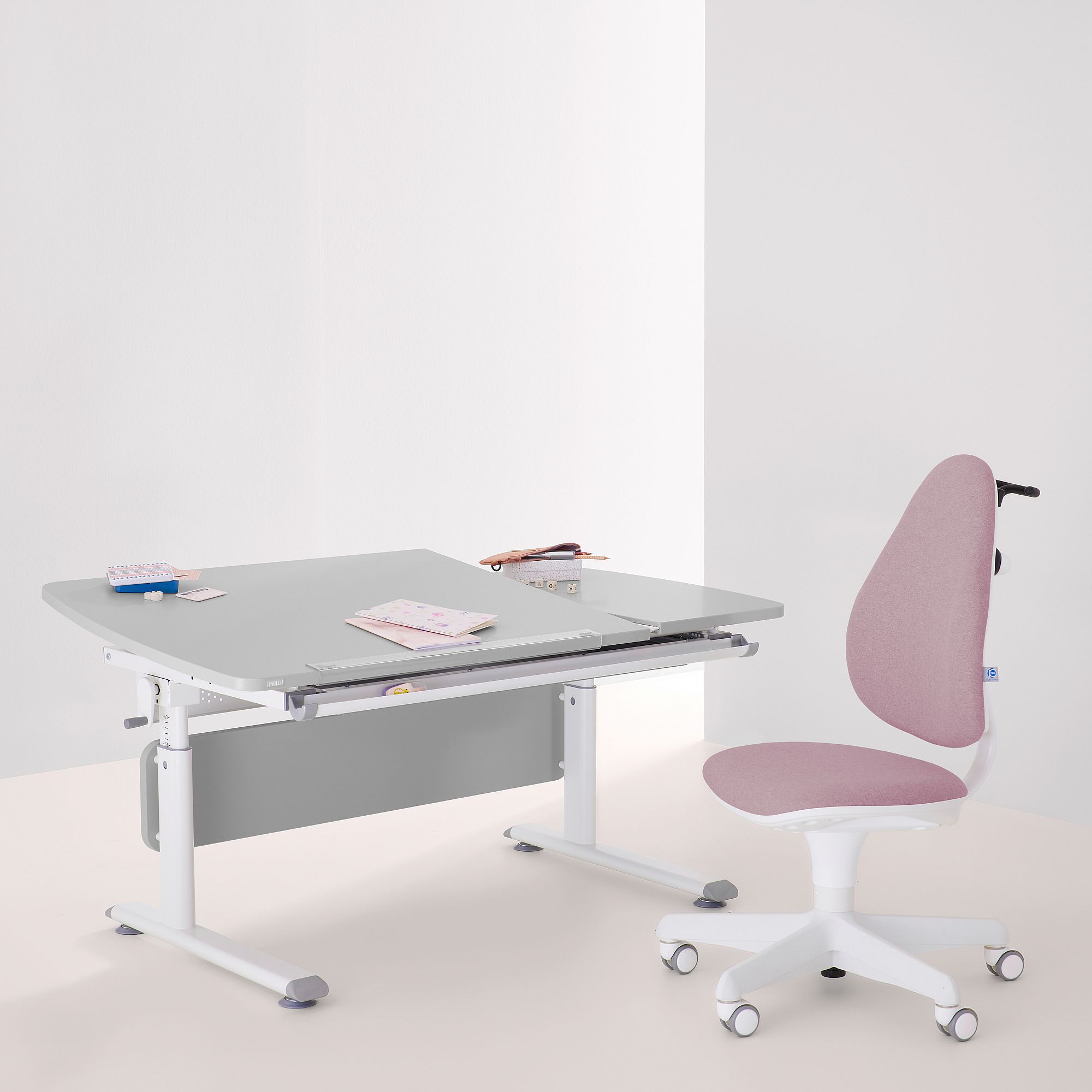 Moderner Schreibtisch mit rosafarbenem Stuhl und Schreibwaren auf einem sauberen, minimalistischen Hintergrund.