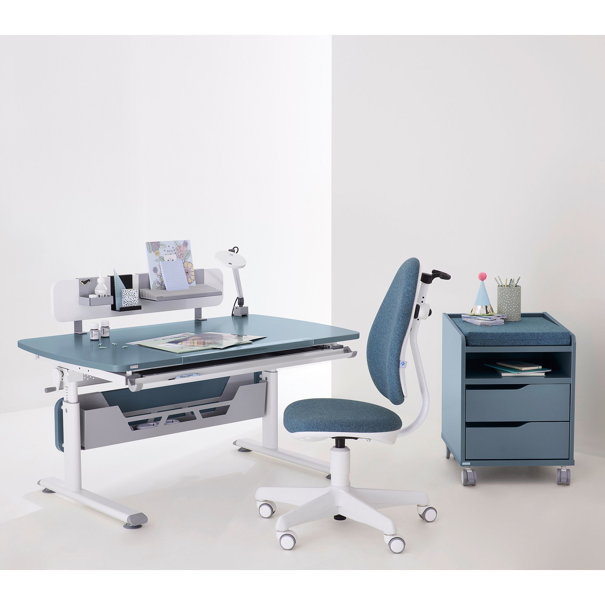 Blauer und weißer Schreibtisch mit Stuhl, Lampe und rollendem Schubladenorganisator.