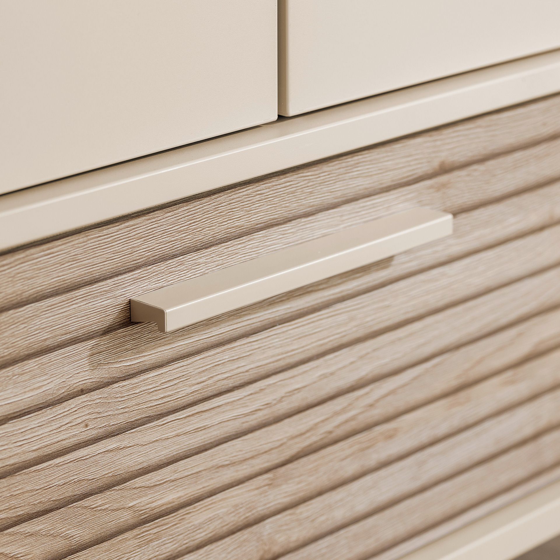 Nahaufnahme einer modernen, beigen Schublade mit strukturierter Holzoptik und einem eleganten Griff.