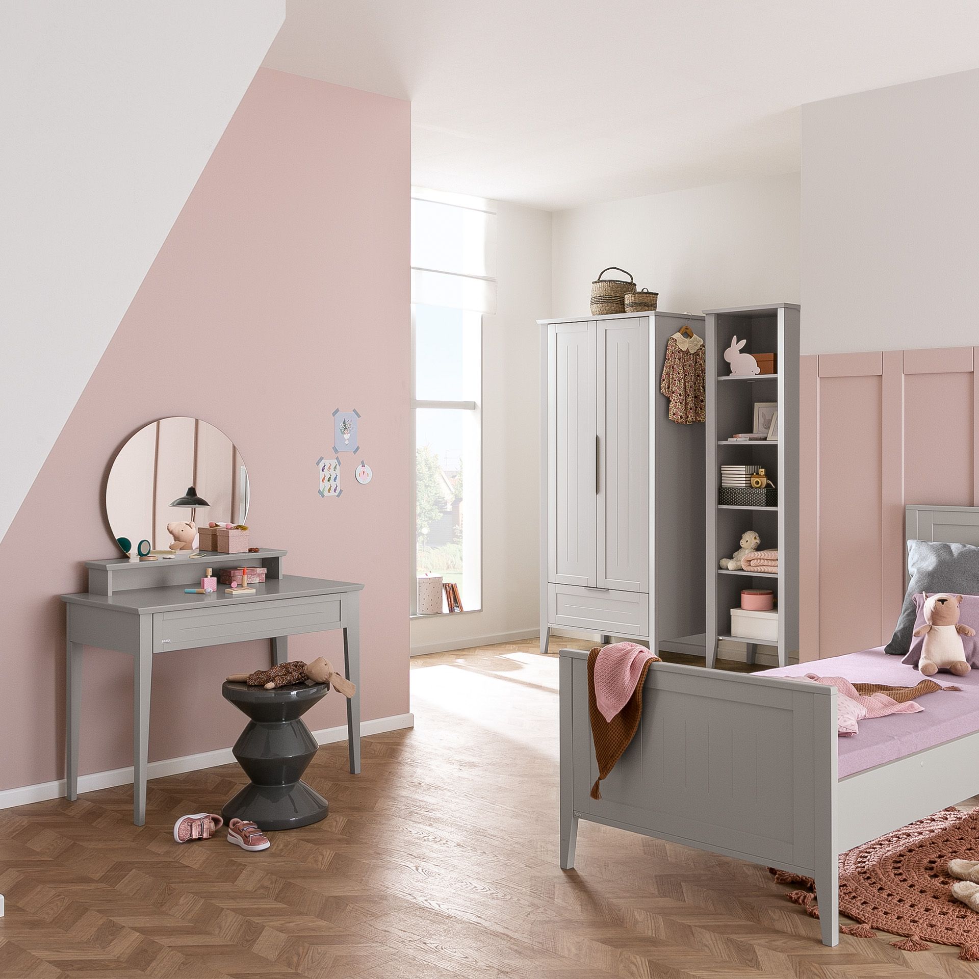 A pastel-themed kids bedroom with a bed, desk, and wardrobe in soft colors.