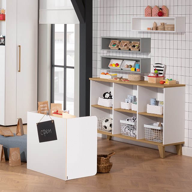 Children’s play store setup with shelves, baskets, and toy groceries.