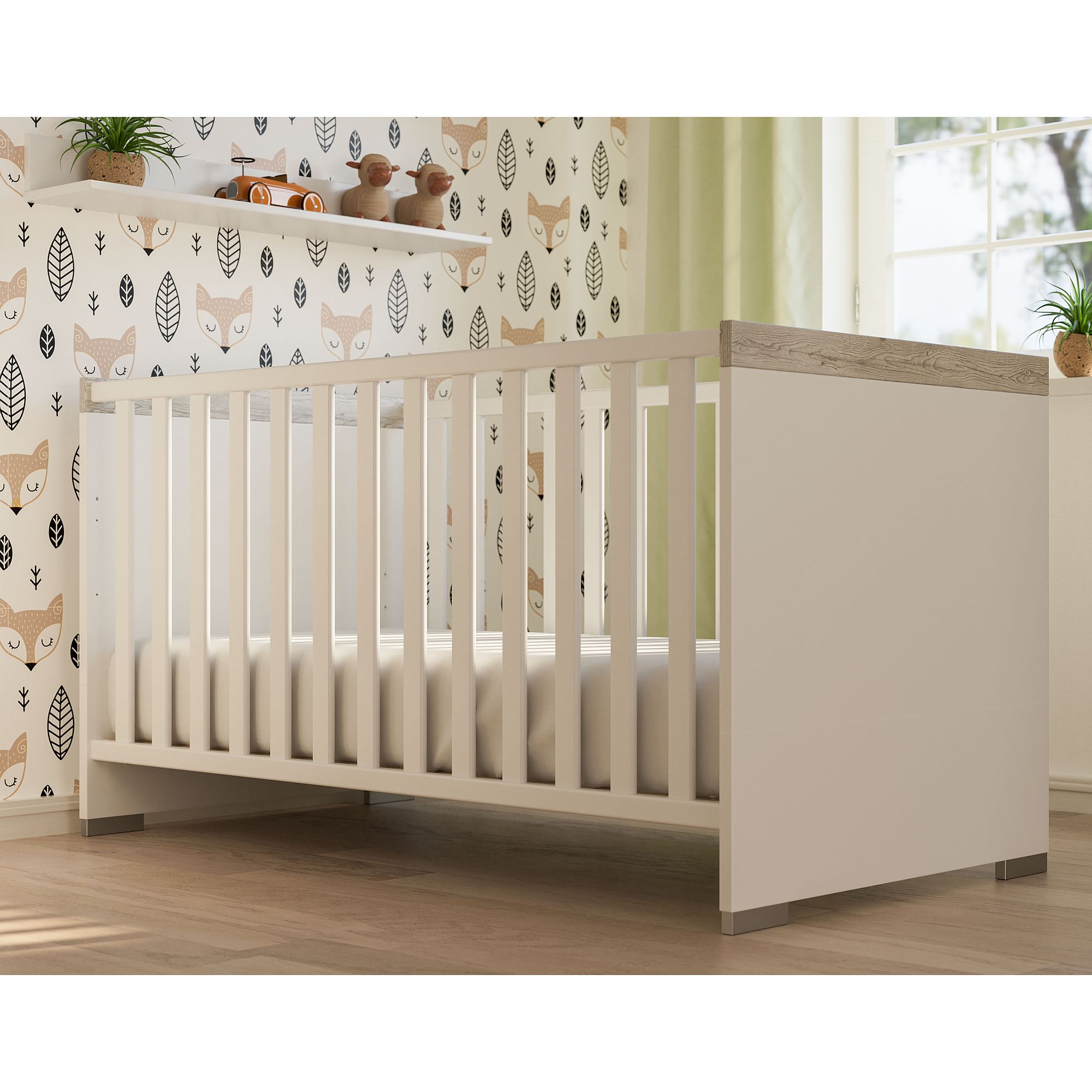 Weißes Babybett in einem Kinderzimmer mit Fuchstapete und einem Fenster.