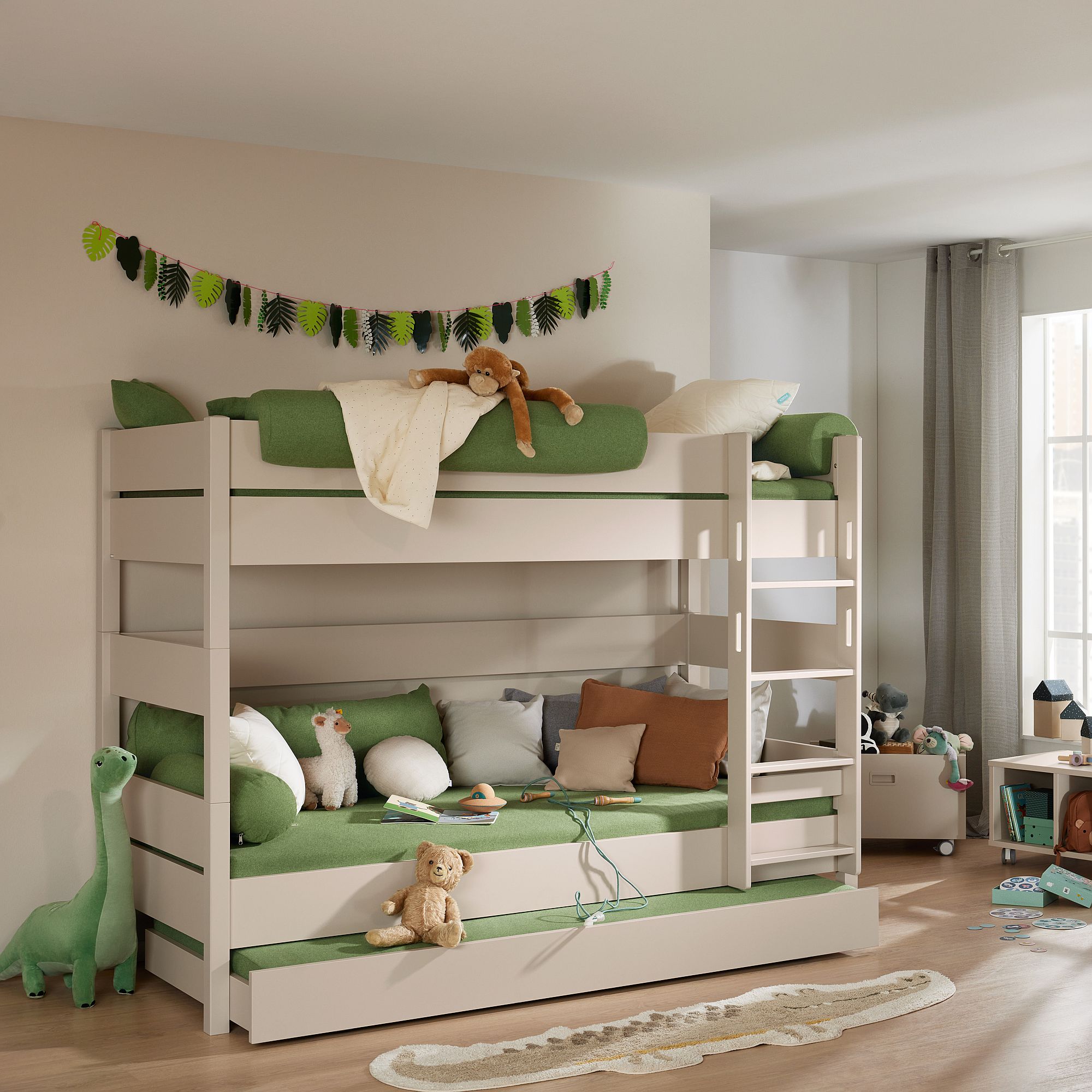 Kinderzimmer mit einem Etagenbett, grüner Bettwäsche, Stofftieren und Spielzeug auf dem Boden.