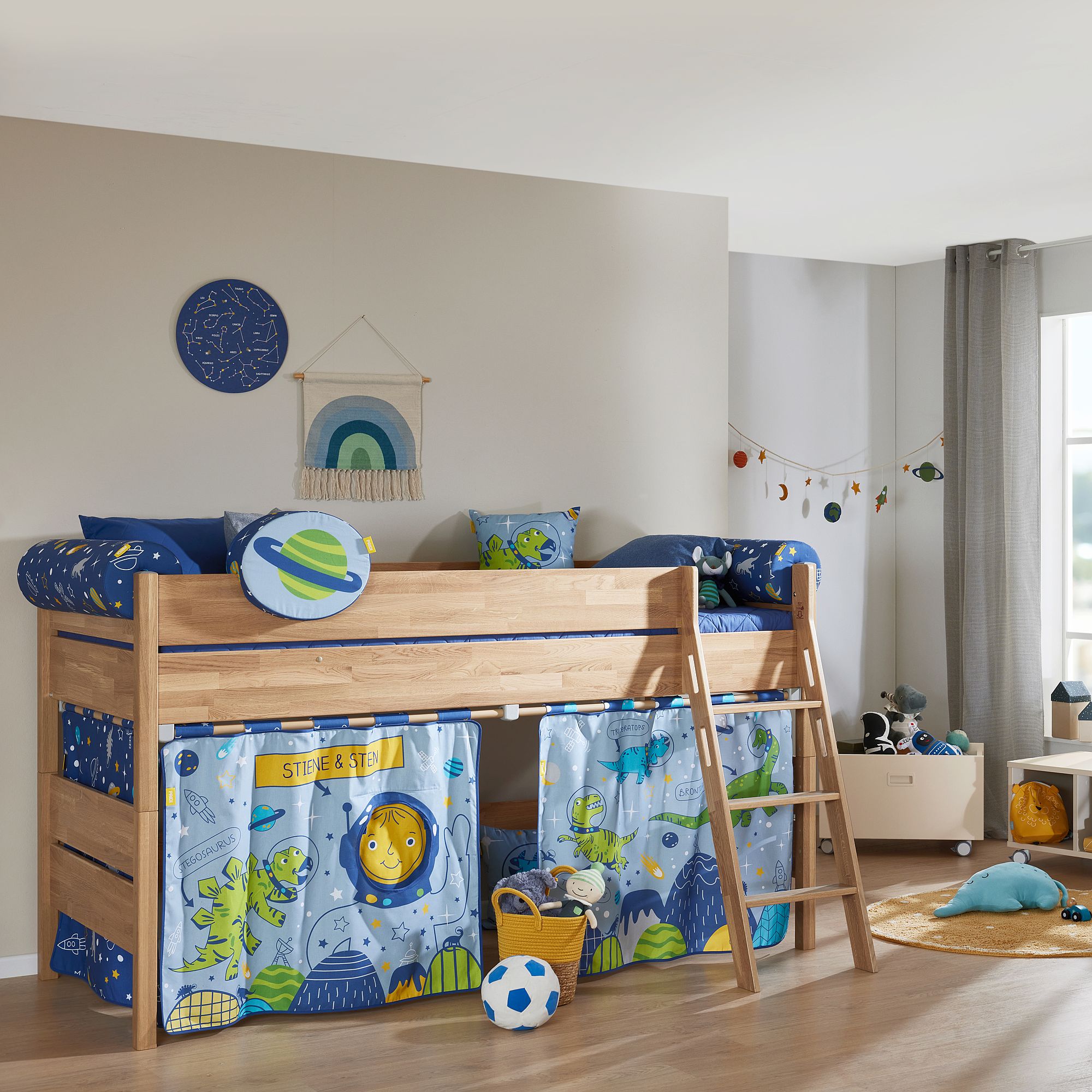 Ein Etagenbett aus Holz mit Bettwäsche im Weltraum-Design in einem hellen, verspielten Kinderzimmer.