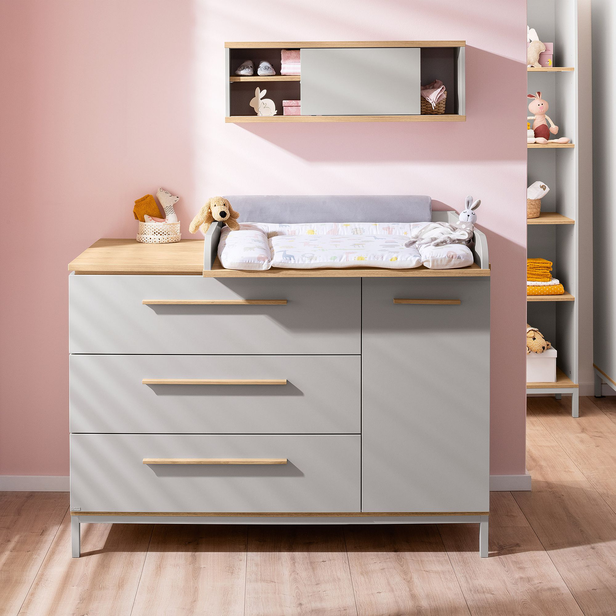 Ein moderner Wickeltisch mit Schubladen, Plüschtieren und Babyzubehör.