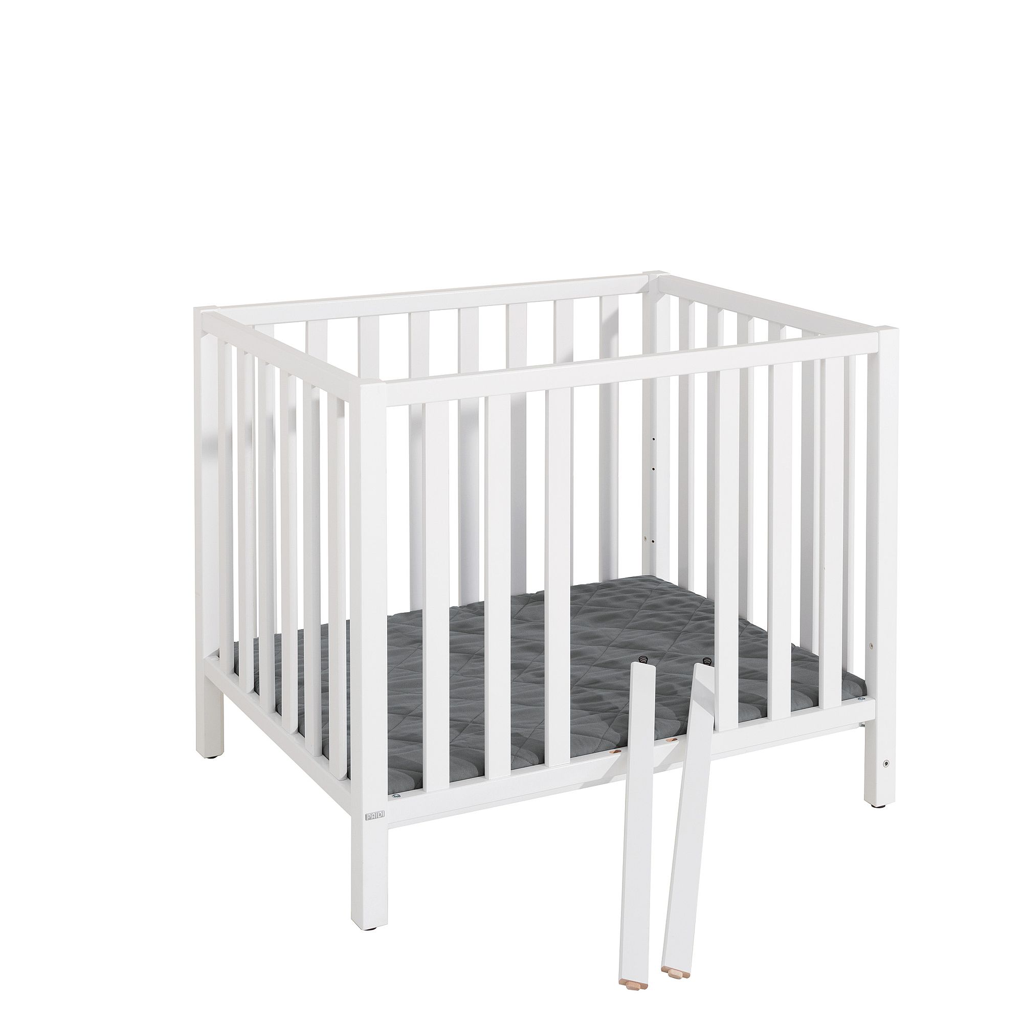 White wooden baby crib with a gray mattress and two loose crib rails in front.