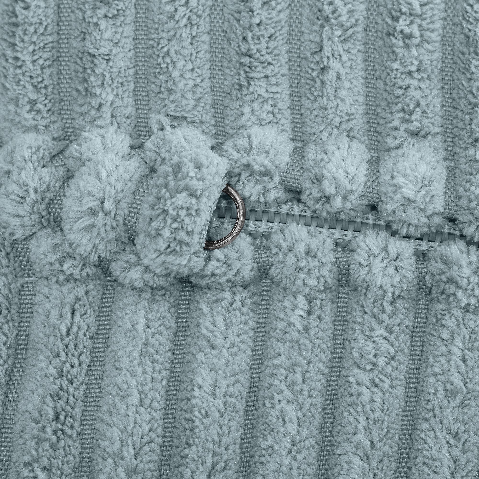 Nahaufnahme eines metallischen Reißverschlusses auf weichem, strukturiertem, gestreiftem Stoff.