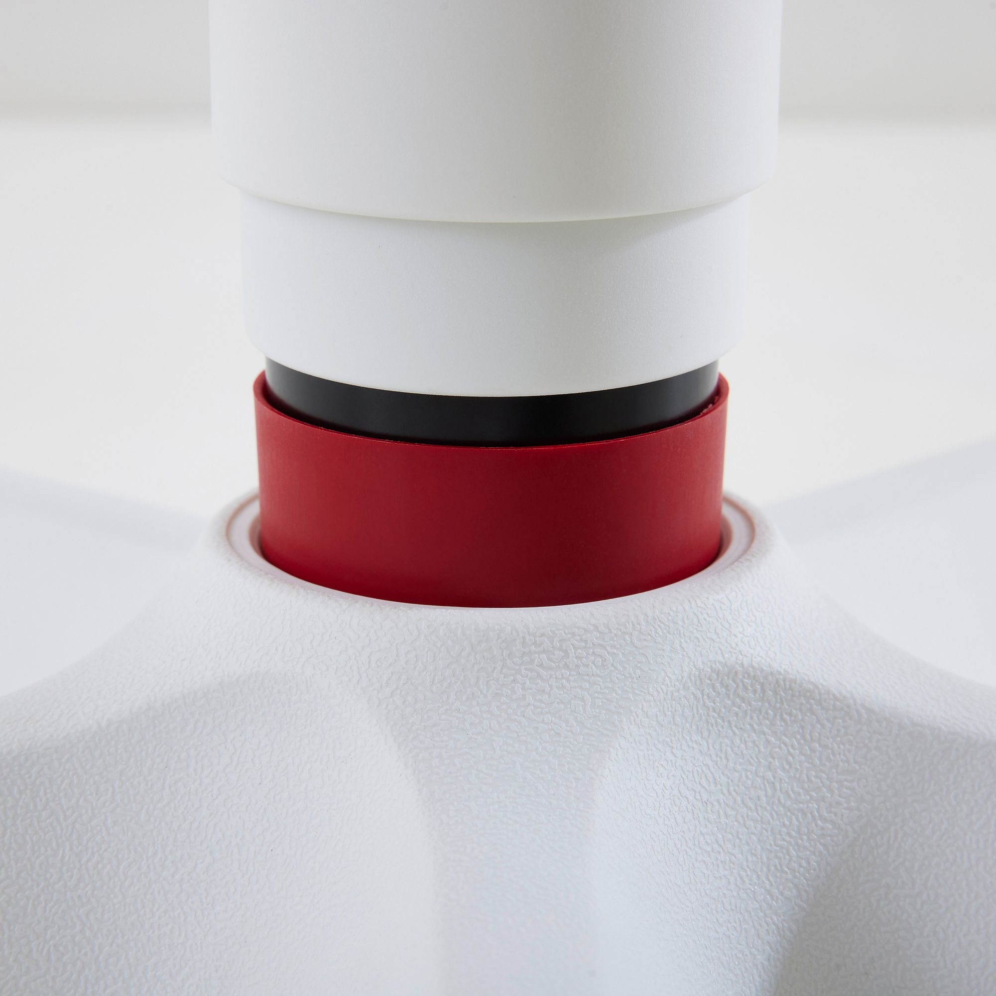 Drehstuhl Jooki S ergonomisch mitwachsend im Mikrofaserbezug Dunkelrosa Nahaufnahme eines weißen Objekts mit einem roten und schwarzen Ring in der Nähe des Zentrums.