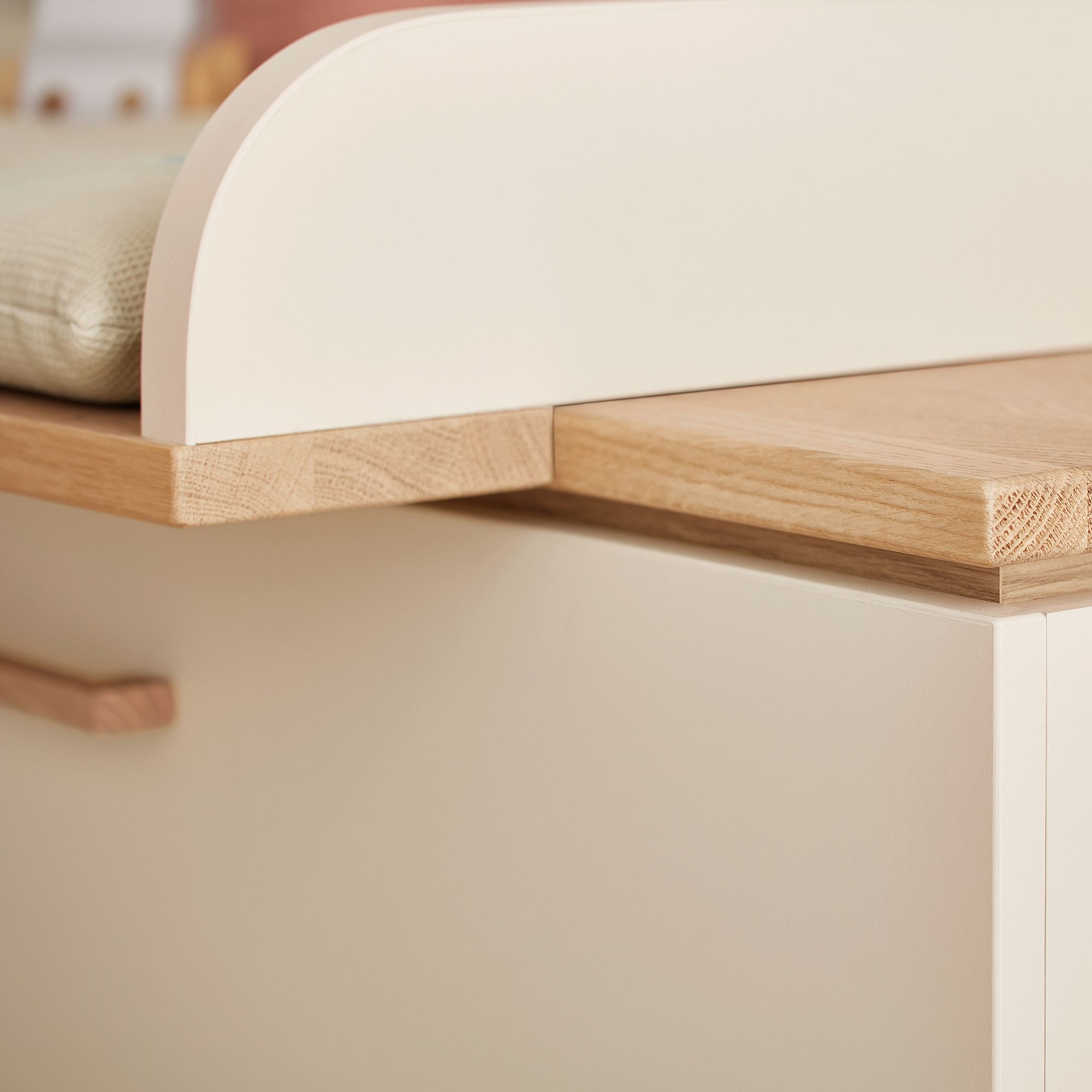 Nahaufnahme eines hellen, cremefarbenen Holzschranks mit abgerundeten Kanten.