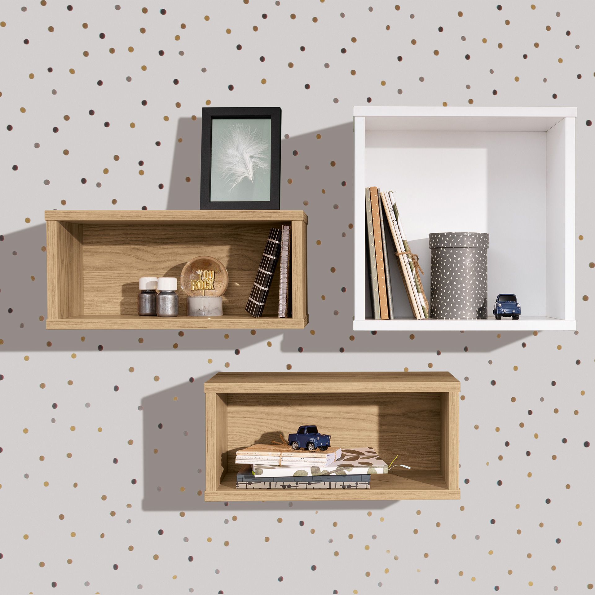 Wandregal  Wandbox  rechteckig  in Eiche-Montana Drei Wandregale mit Büchern, Dekoration und Spielzeugautos vor einer gepunkteten Wand.
