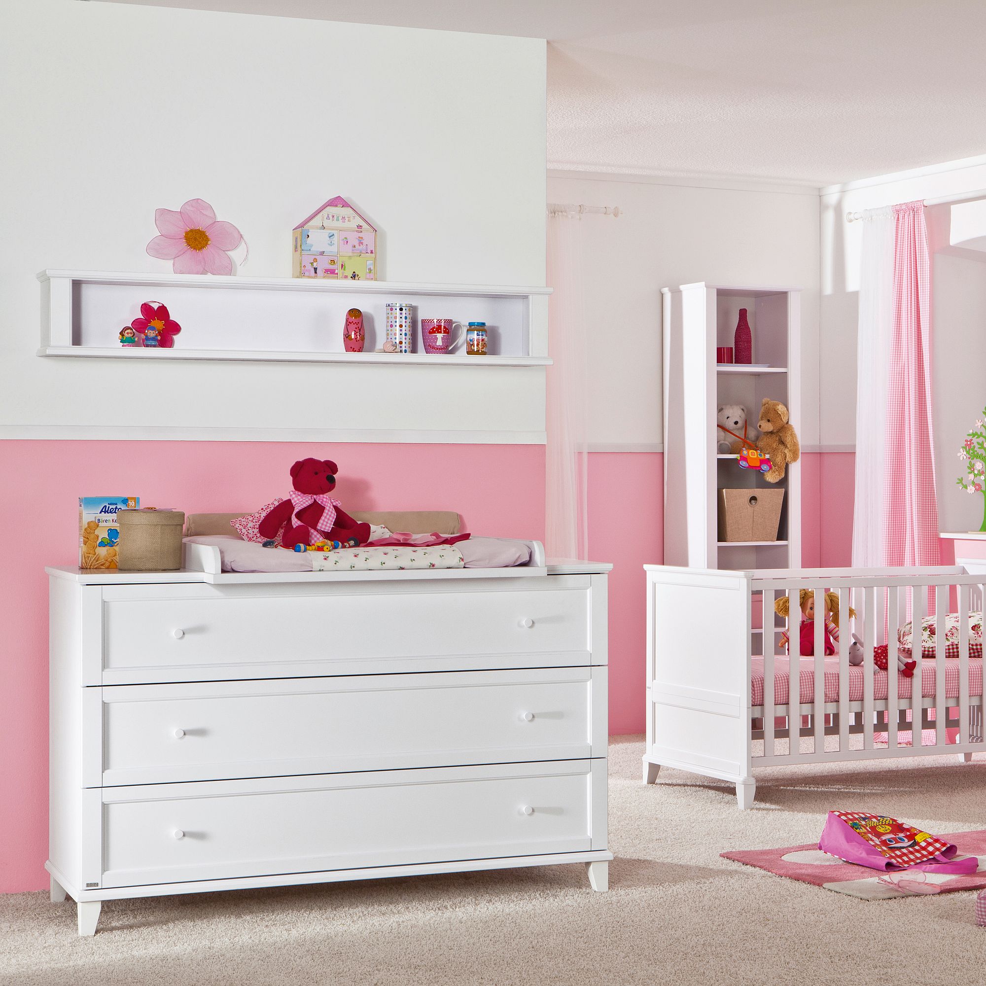White nursery room with pink accents, crib, dresser, and stuffed animals.