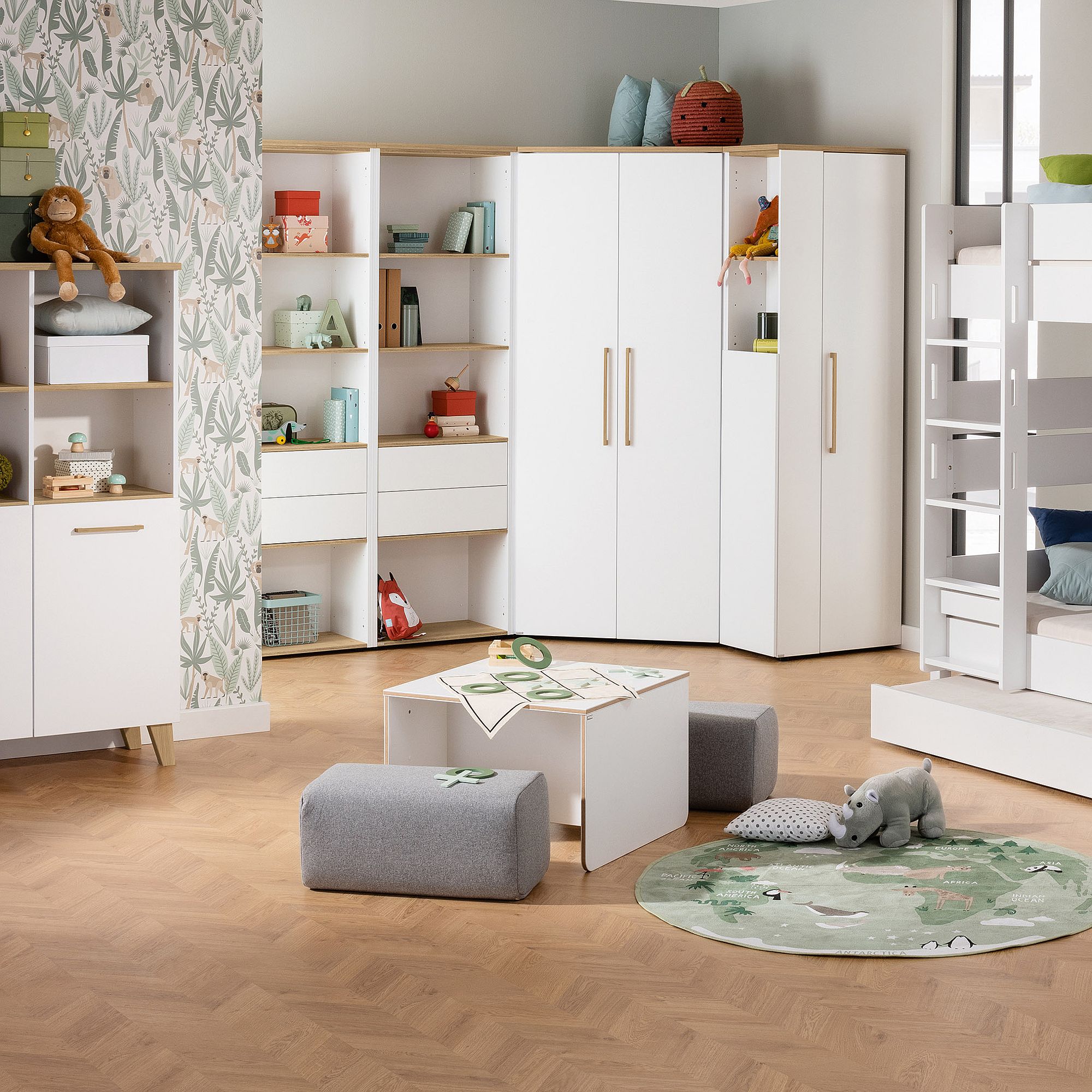 Modernes Kinderzimmer mit weißen Möbeln, Bücherregalen, Spielzeug und Tierdekor.