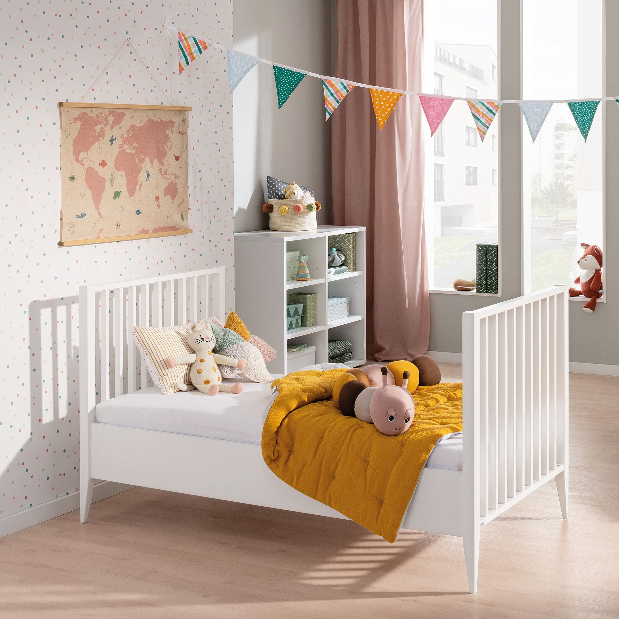 Modernes Kinderzimmer mit weißem Bett, Spielzeug und buntem Wimpeldekor.