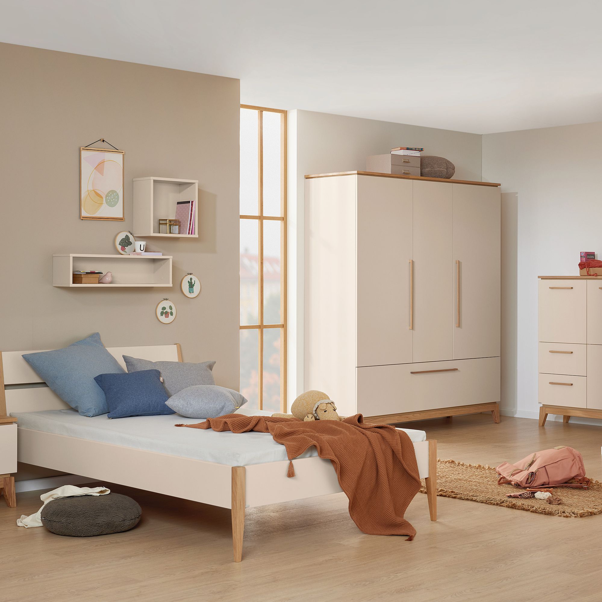 Minimalistisches Schlafzimmer mit einem Einzelbett, einem Kleiderschrank, Regalen und einer neutralen Einrichtung.