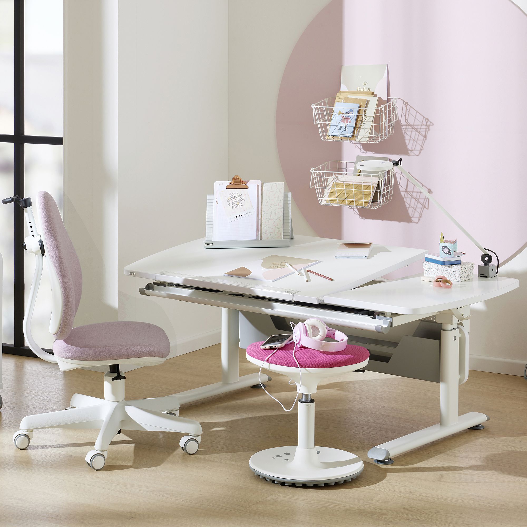 Schülerschreibtisch Diego GT Curved 130 x 70 cm, Kreideweiß Modern white desk setup with pink chair, headphones, and organized shelves.