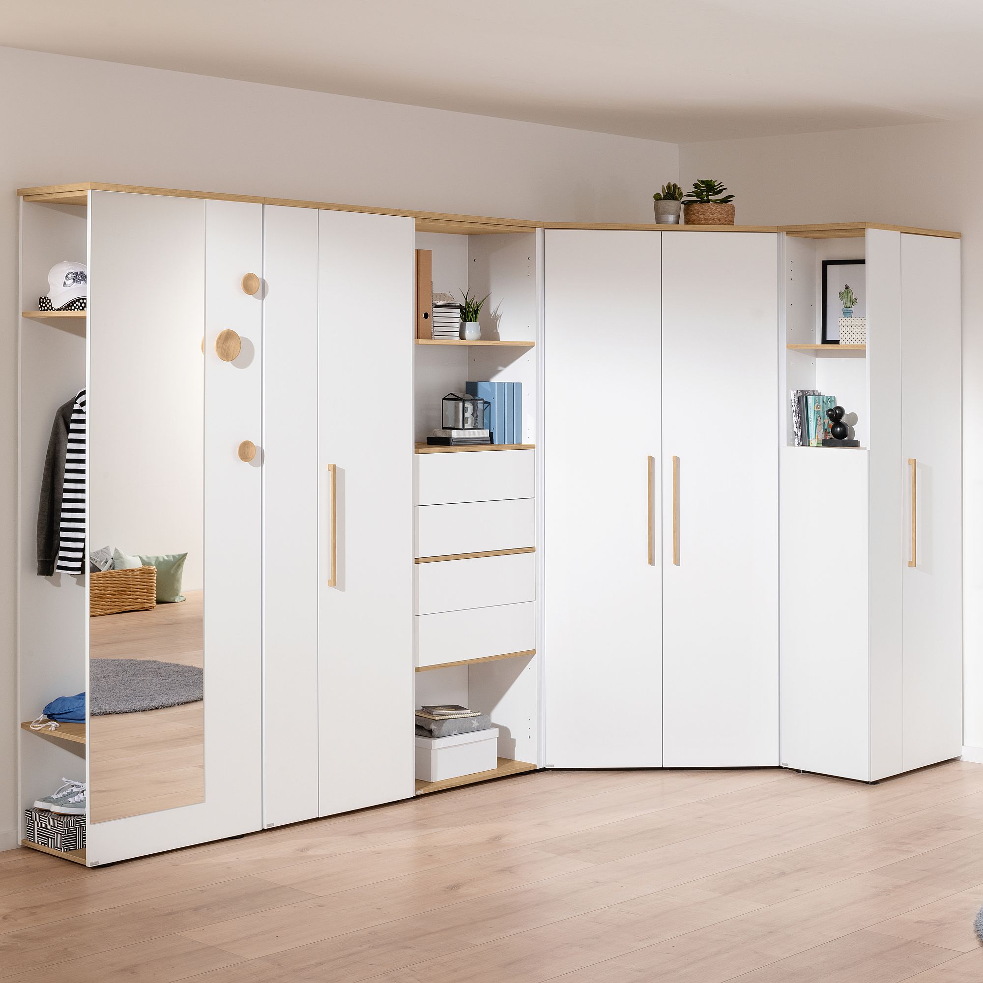 Modernes, weißes, modulares Kleiderschranksystem mit Regalen, Schubladen und einem Spiegel.