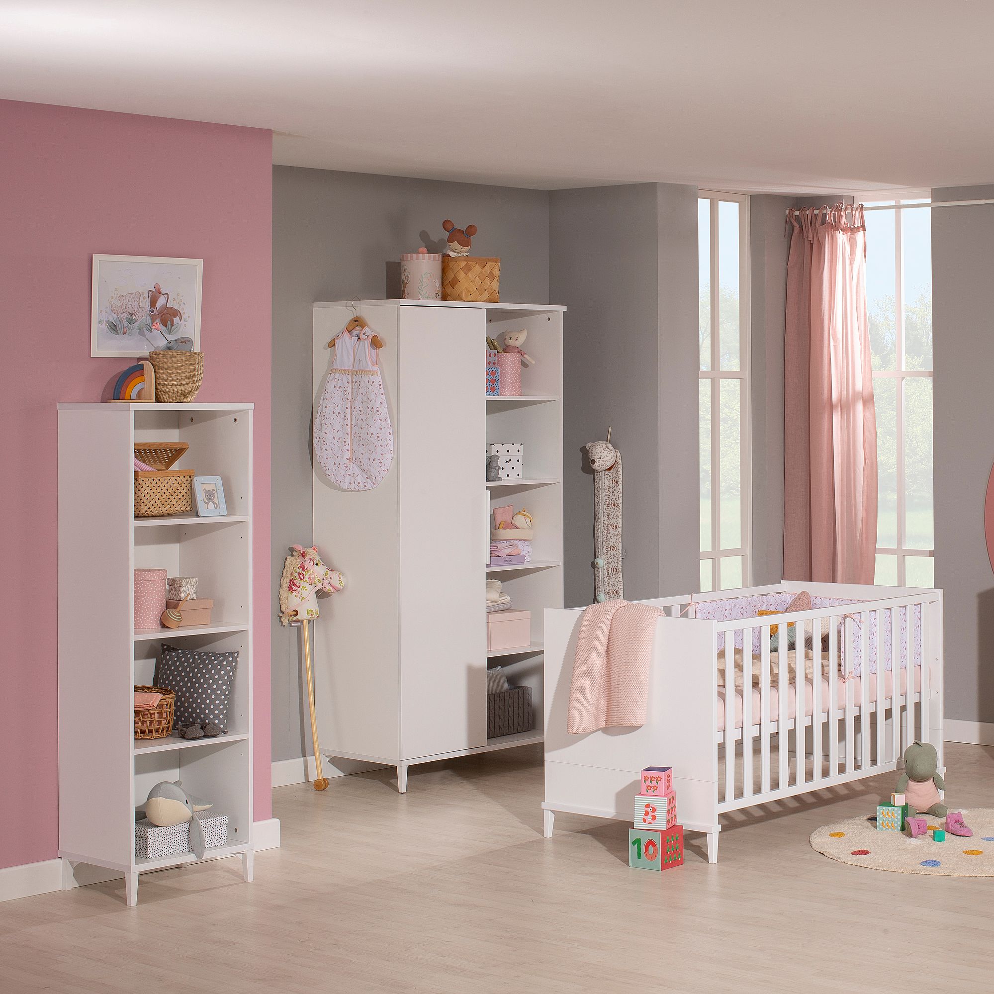Modernes Babyzimmer mit Kinderbett, Regalen, Spielzeug und rosa-grauer Einrichtung.