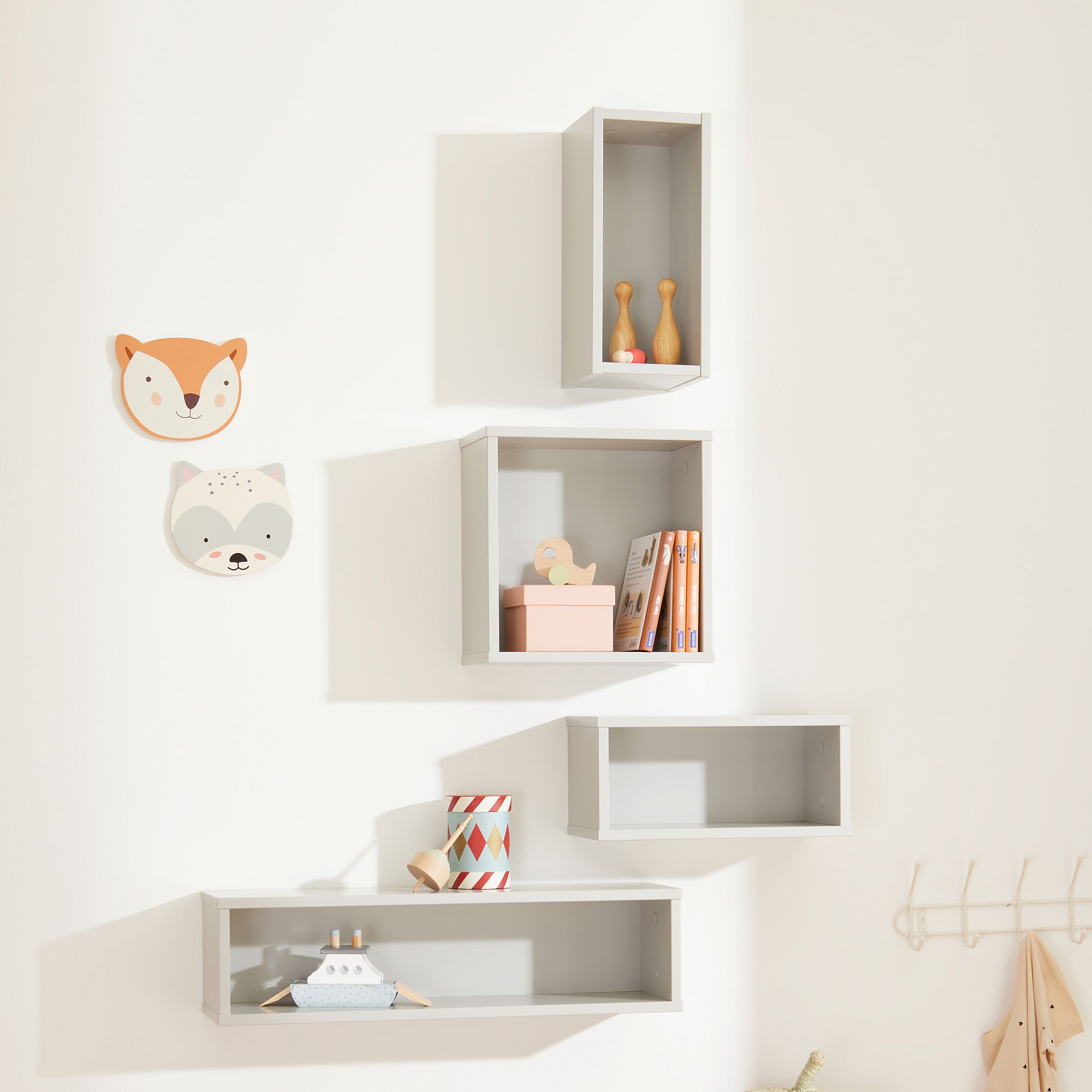 Wandregal  Wandbox rechteckig  in Kreideweiß Vier Kistenregale mit Spielzeug und Büchern, darüber zwei tierische Wanddekorationen.