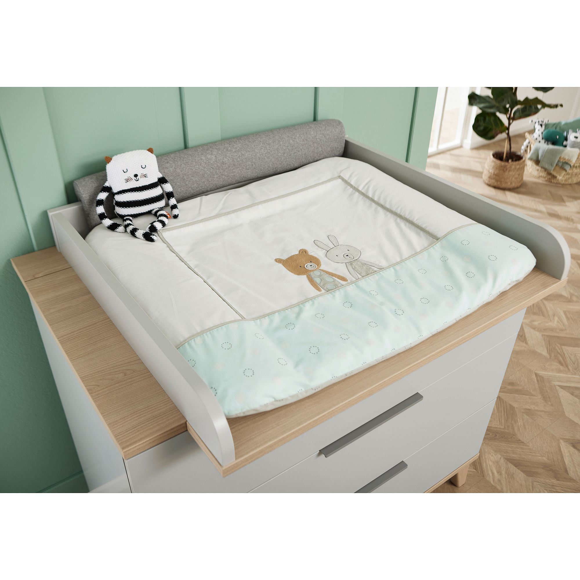 Wickelaufsatz Fiene zur Erweiterung der Wickelkommode mit 3 Schubladen Wickeltisch mit einer niedlichen Matte mit Tiermotiven und einem gestreiften Stofftier.