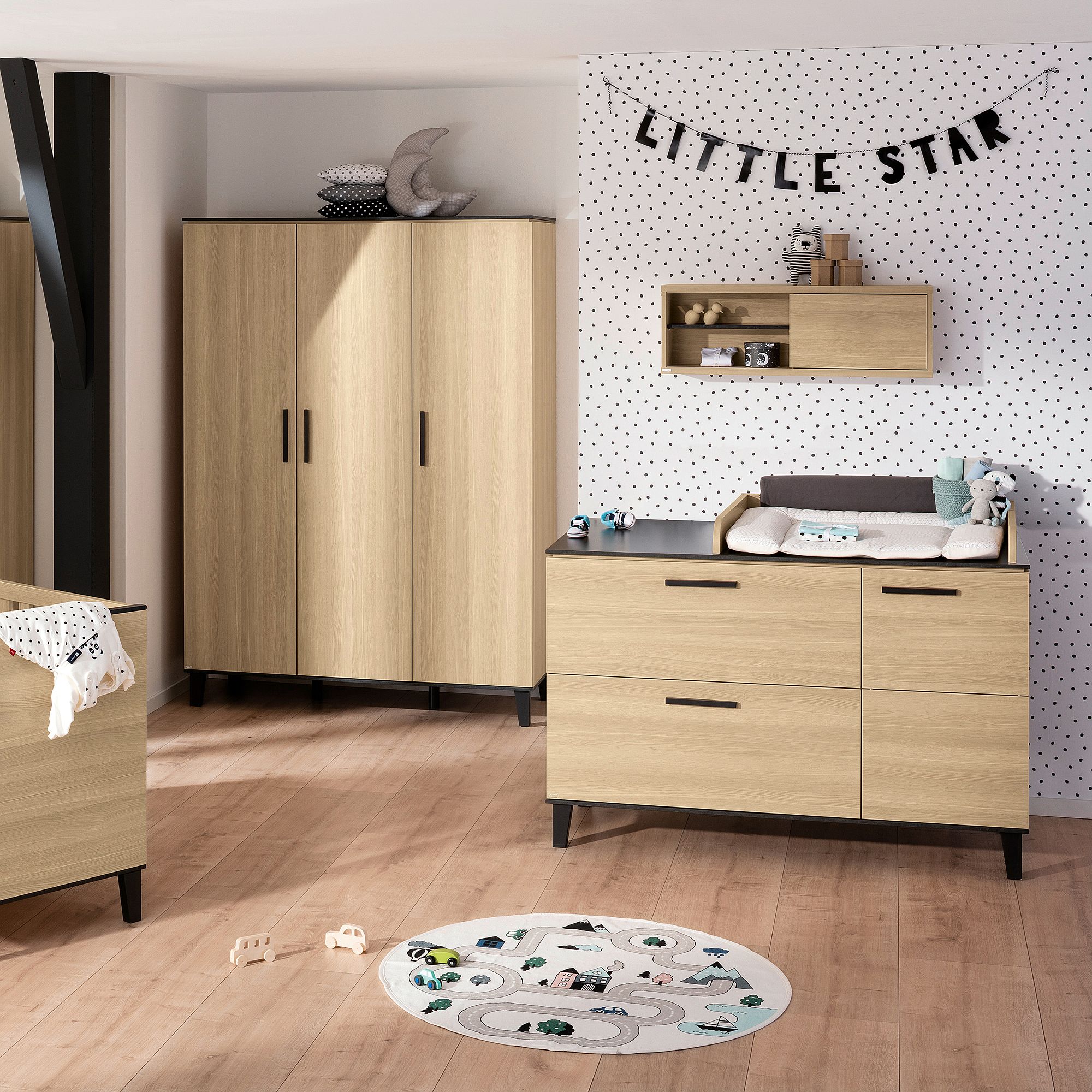 Modernes Kinderzimmer mit Holzmöbeln, gepunkteter Wand und einem „Little Star“-Banner.