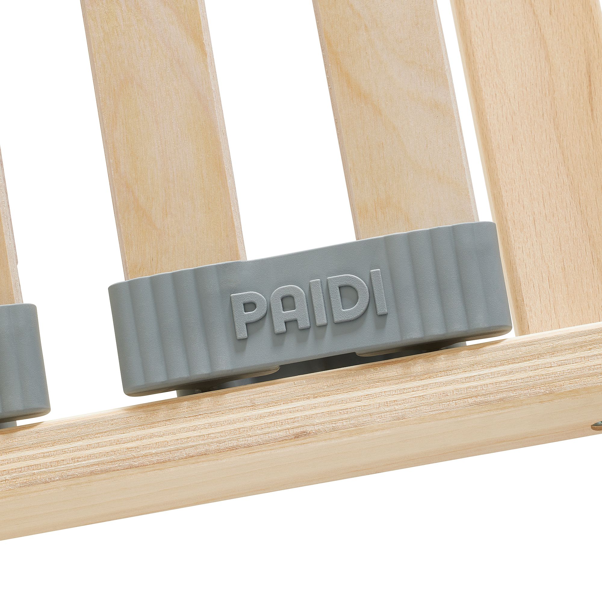 Lattenrost  Comfort mit Härteverstellung in 90 x 200 cm Grauer Kunststoffknopf mit der Aufschrift PAIDI auf einer hellen Holzlattenoberfläche.