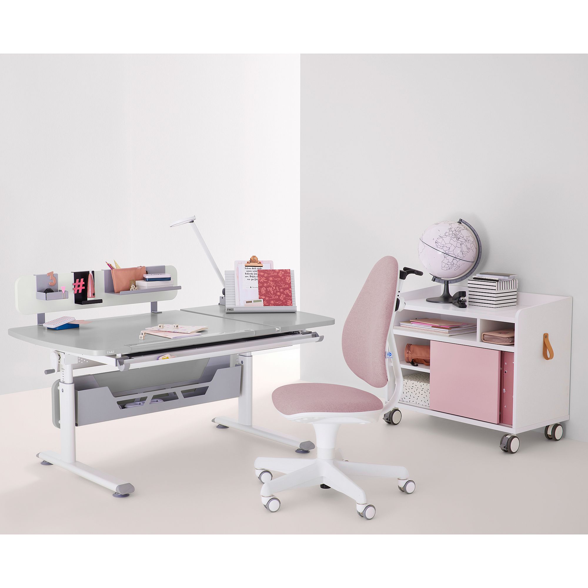 Moderner Schreibtisch mit rosa Stuhl, Globus, Lampe und geordneten Regalen.