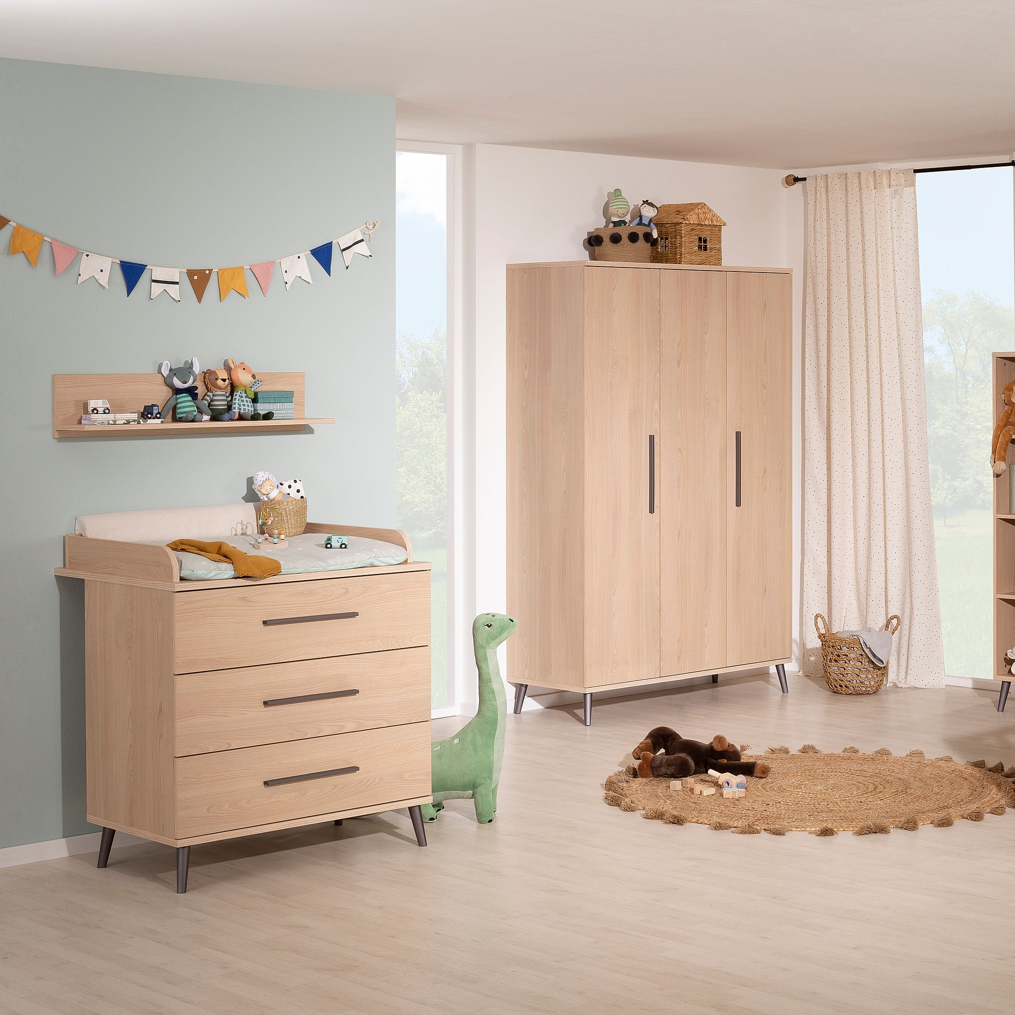 Modernes Kinderzimmer mit hellen Holzmöbeln, Kuscheltieren und verspieltem Dekor.