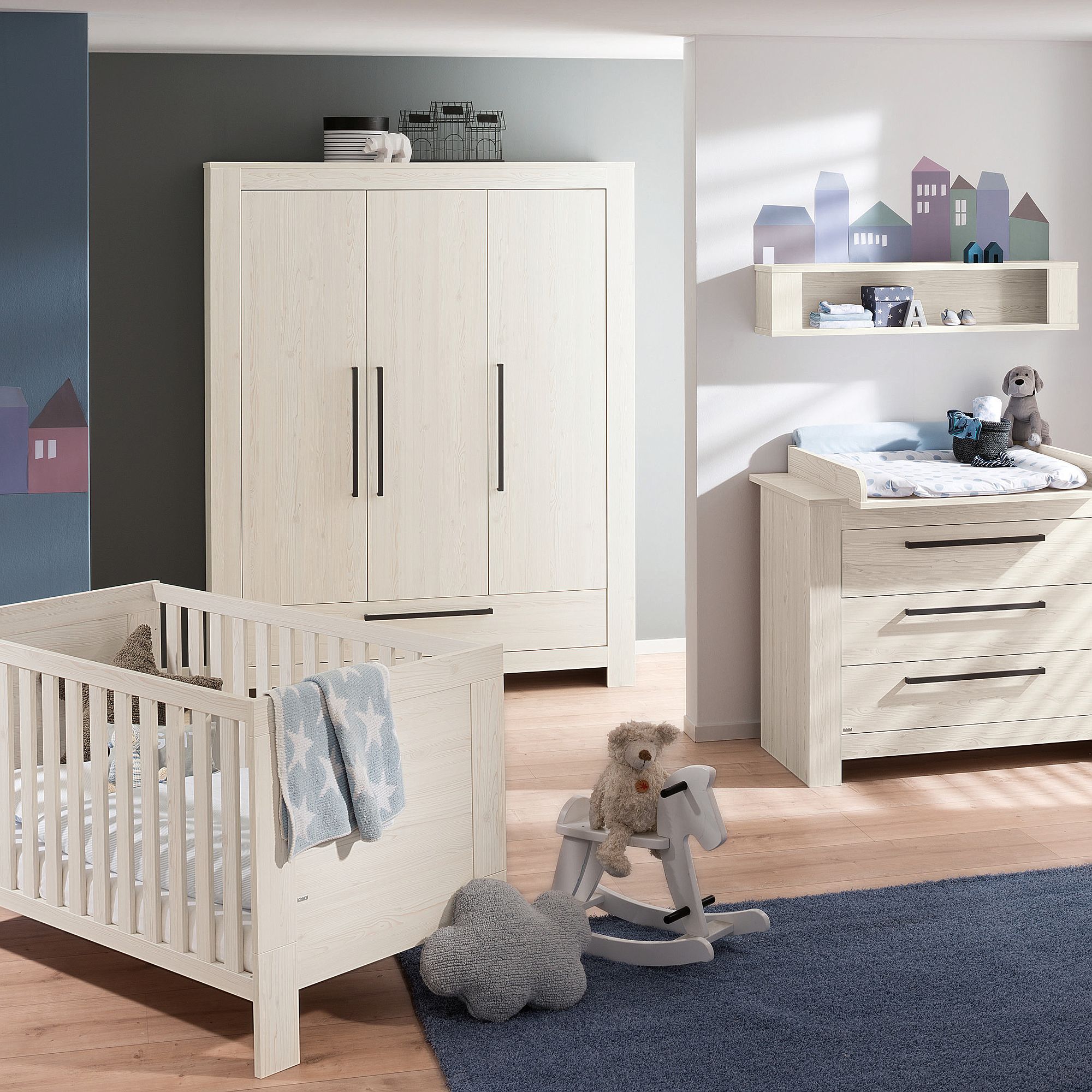 Drehtürenschrank Laslo 3 Türen, 1 Schublade Modernes Kinderzimmer mit weißen Möbeln, Kinderbett, Kommode, Kleiderschrank und Spielzeug.