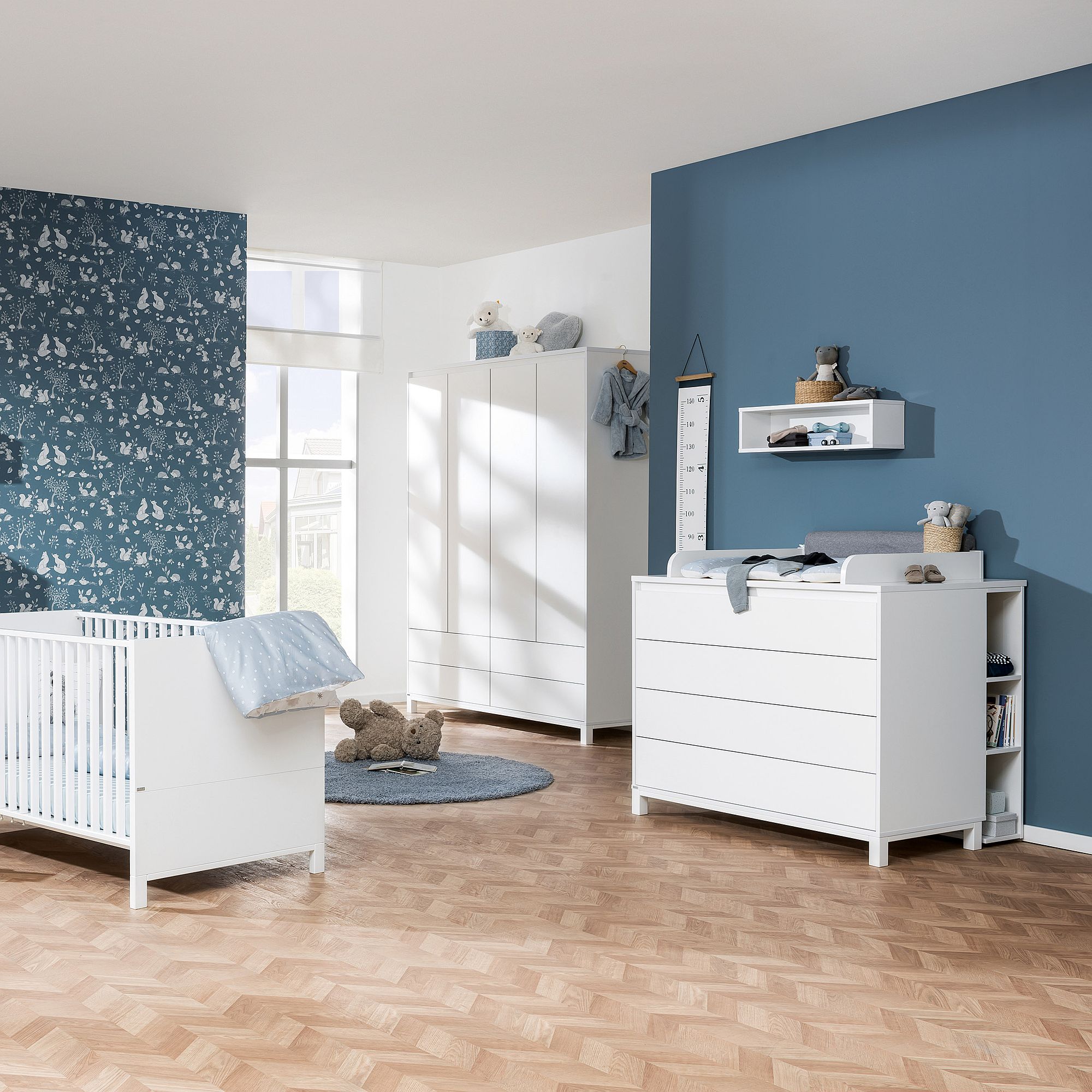 Modernes Babyzimmer mit weißen Möbeln, blauen Wänden und verspieltem Dekor.
