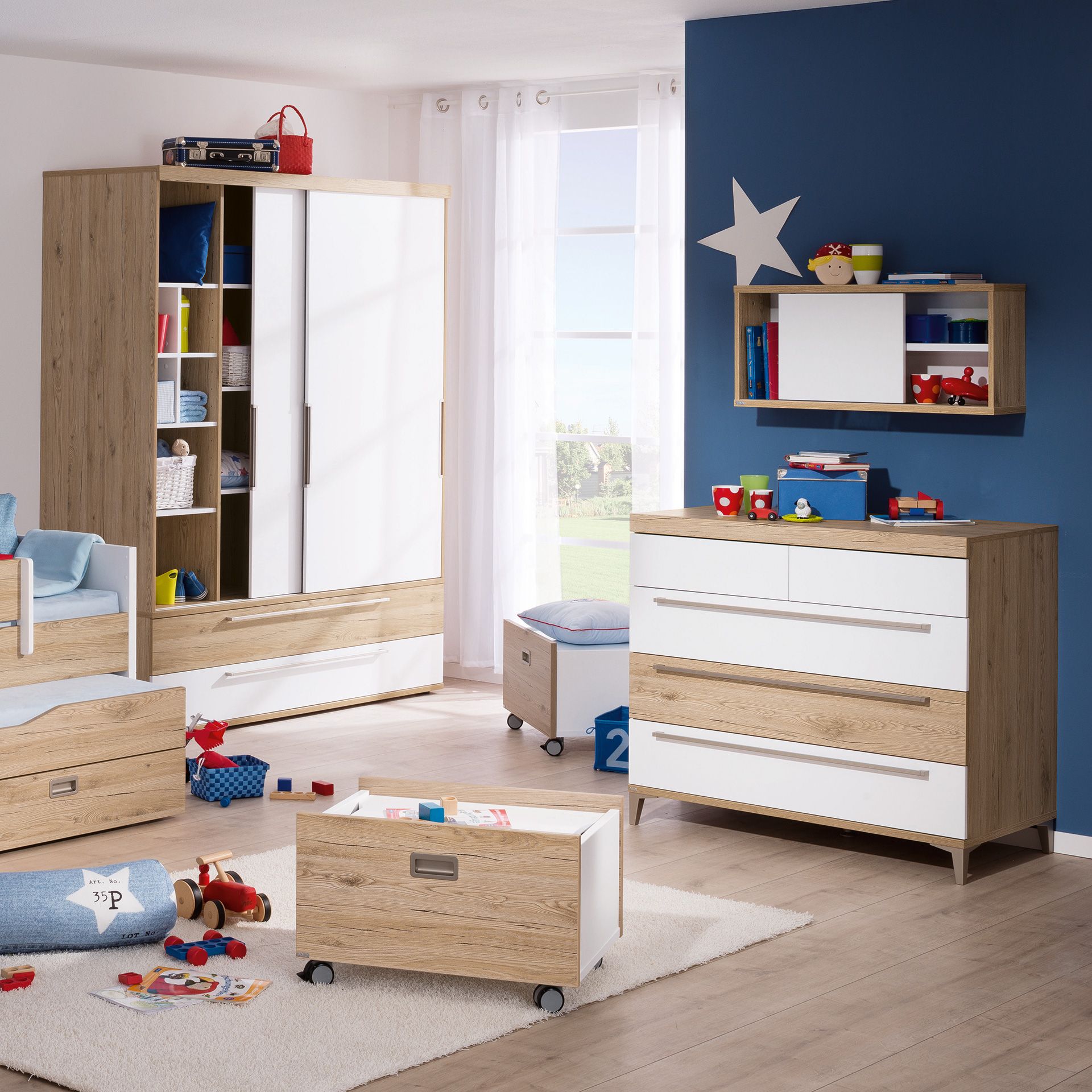 Kinderzimmer mit Holzmöbeln, Spielzeug und einer blau-weißen Einrichtung.