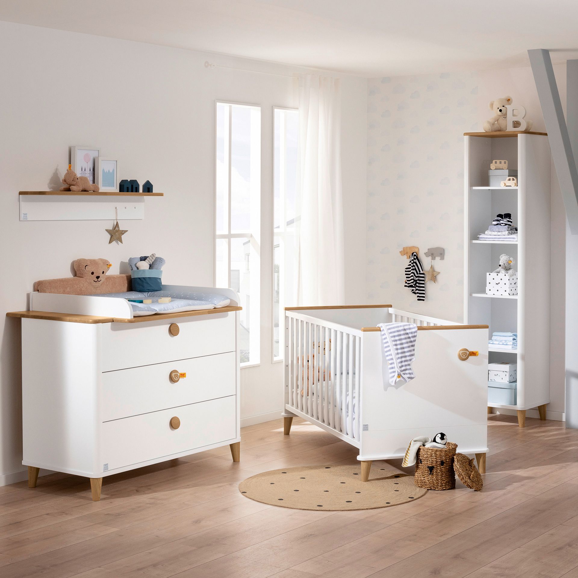 Wickelaufsatz Lotte & Fynn - Steiff by PAIDI zur Erweiterung der Wickelkommode mit 3 Schubladen Modernes Kinderzimmer mit einem Kinderbett, einer Kommode, Regalen und Kuscheltieren in neutralen Tönen.